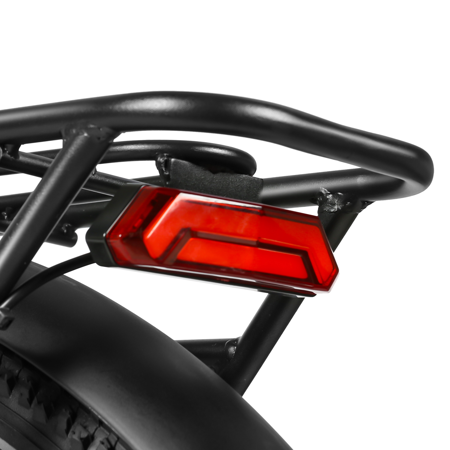 Zbliżenie tyłu roweru elektrycznego pokazujące czarny bagażnik i czerwony odblask.