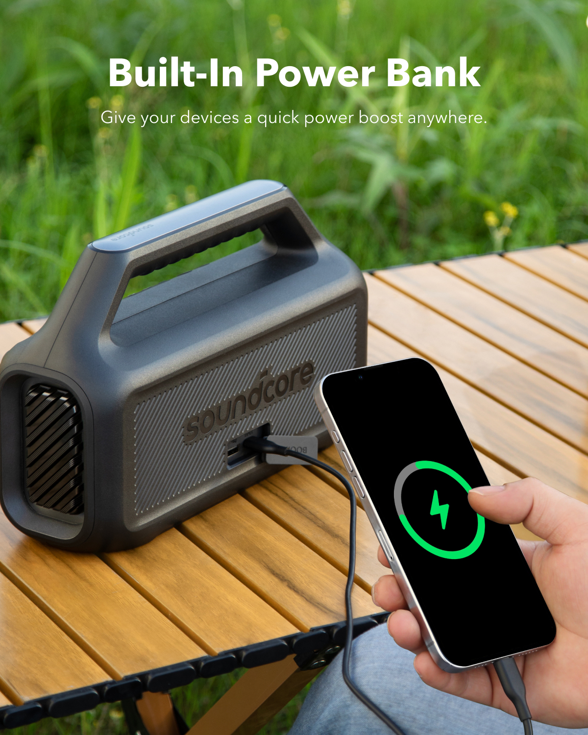 Una persona tiene in mano uno smartphone che si carica da un altoparlante nero. Il testo recita 'Built-In Power Bank'.