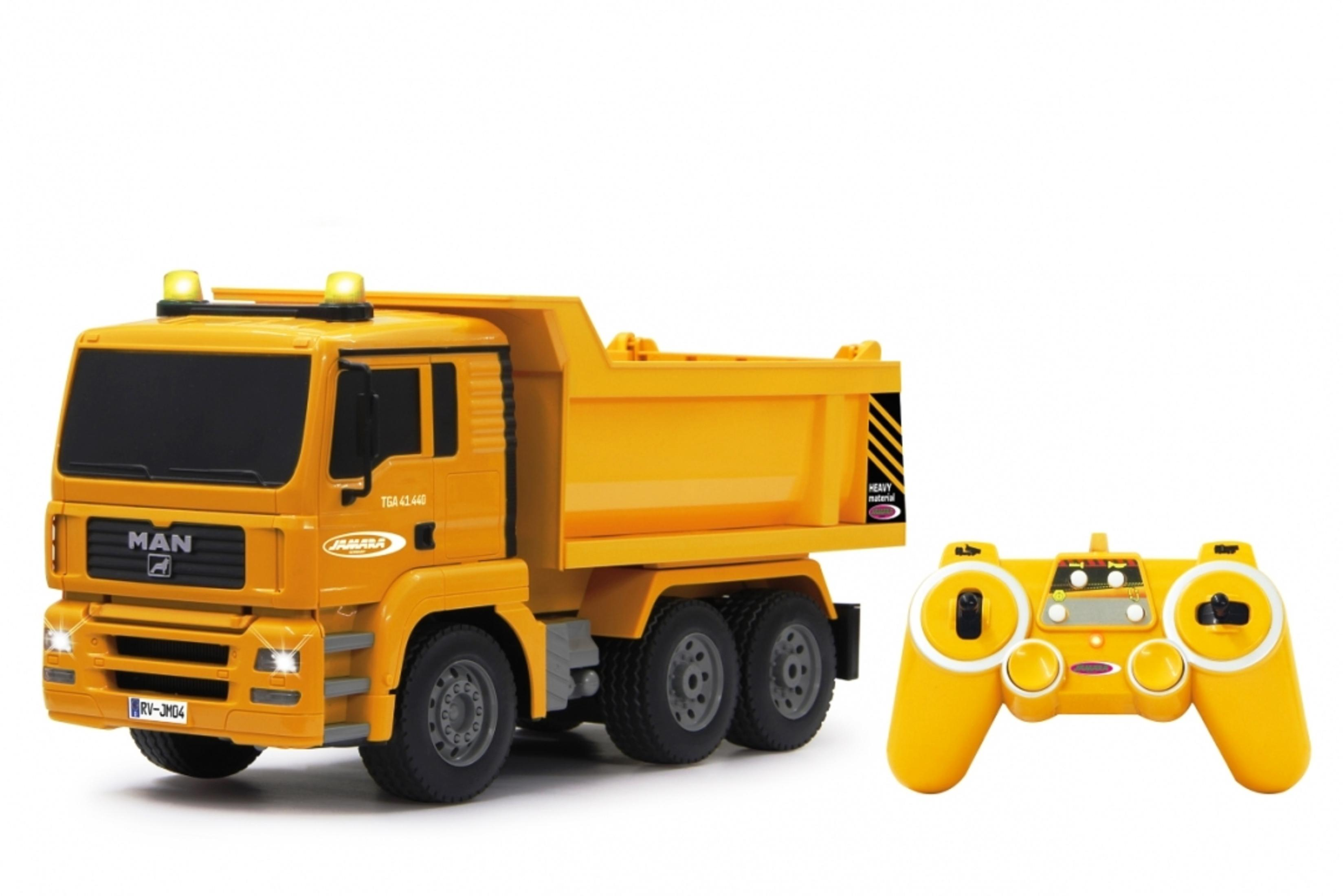 Żółta zabawka wywrotka z pilotem. Ciężarówka stoi na białej powierzchni.