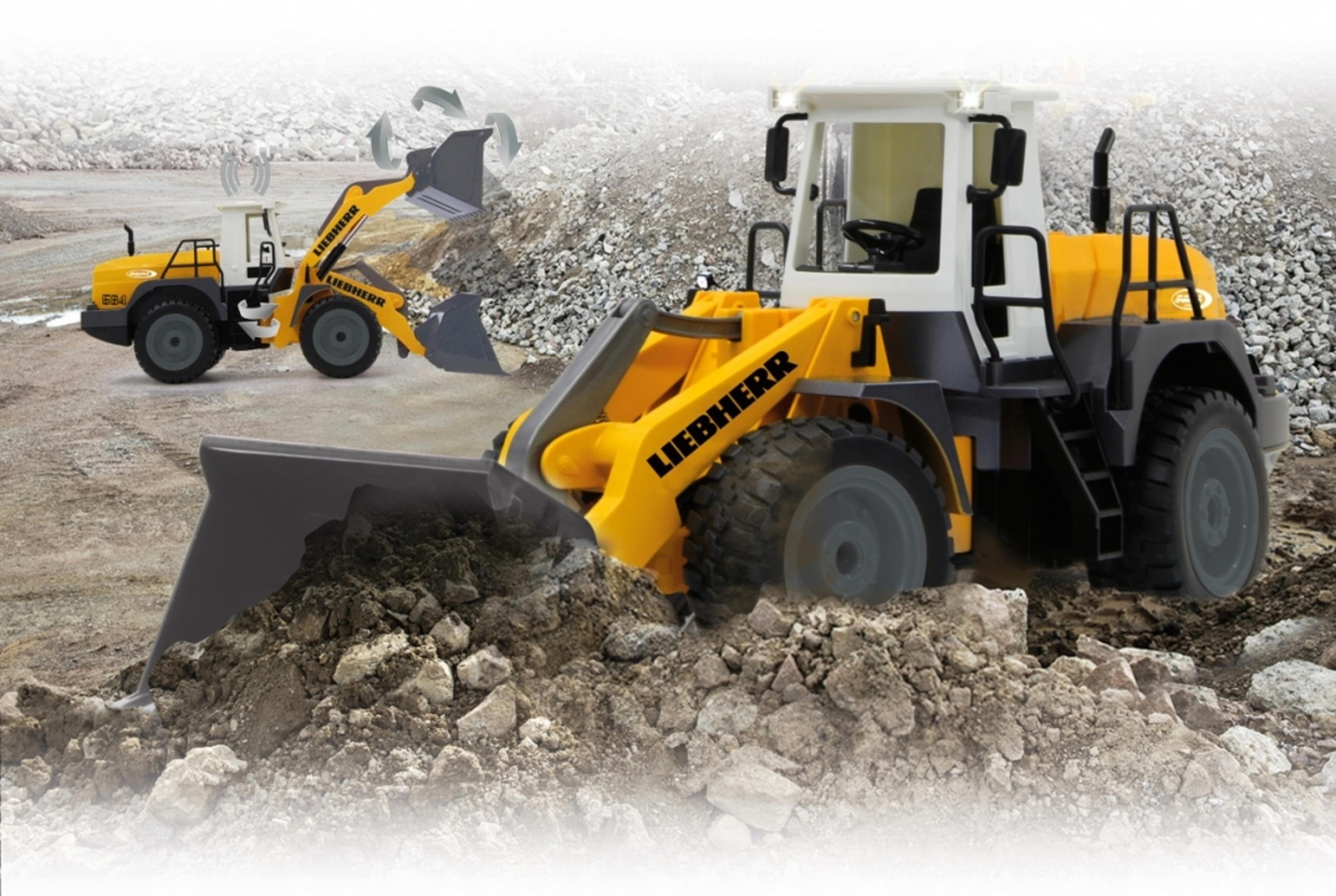 Zabawkowa ładowarka czołowa, żółto-szara, w otoczeniu placu budowy.