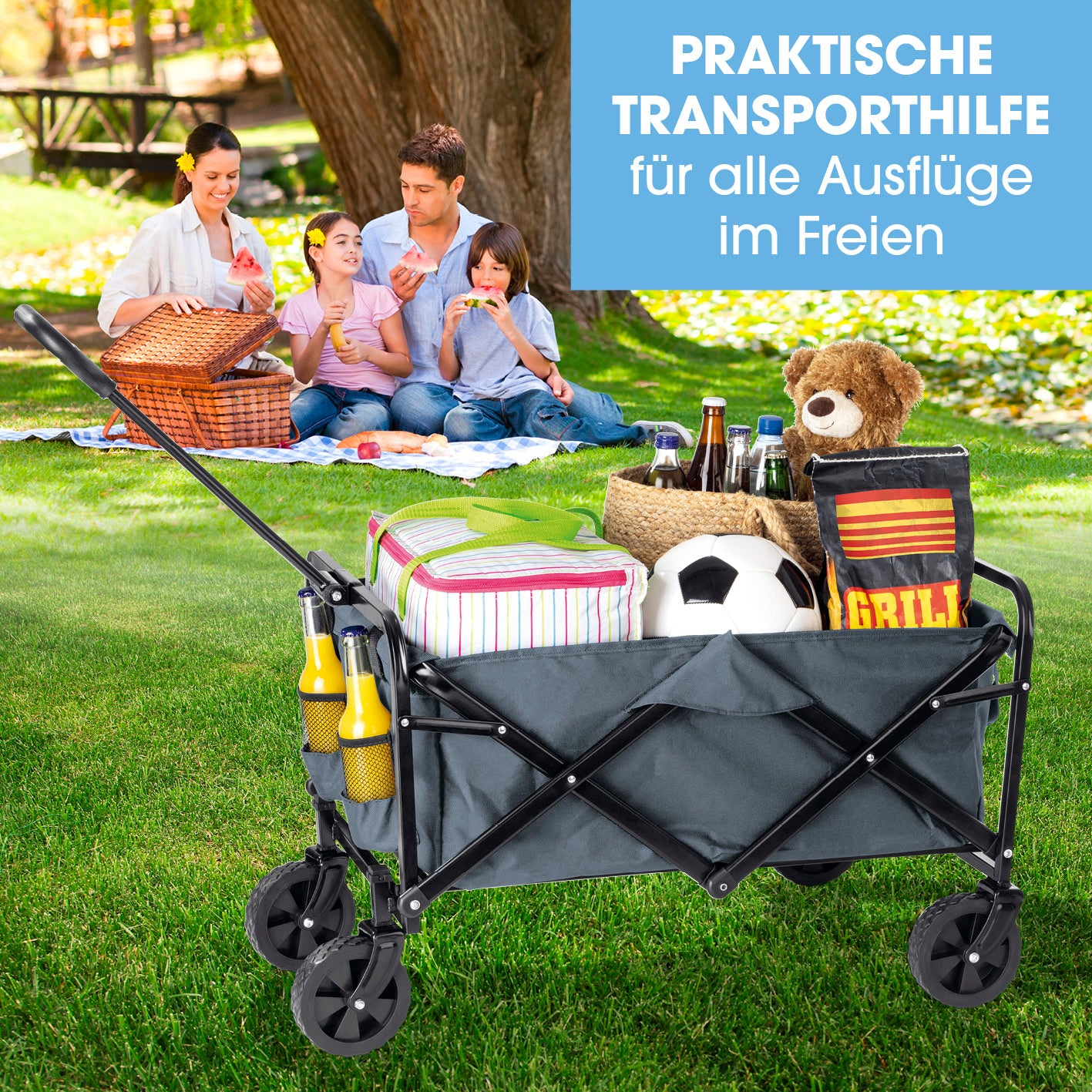 Eine Familie genießt ein Picknick neben einem Wagen mit Picknickartikeln und Spielzeug in einem grünen Park.