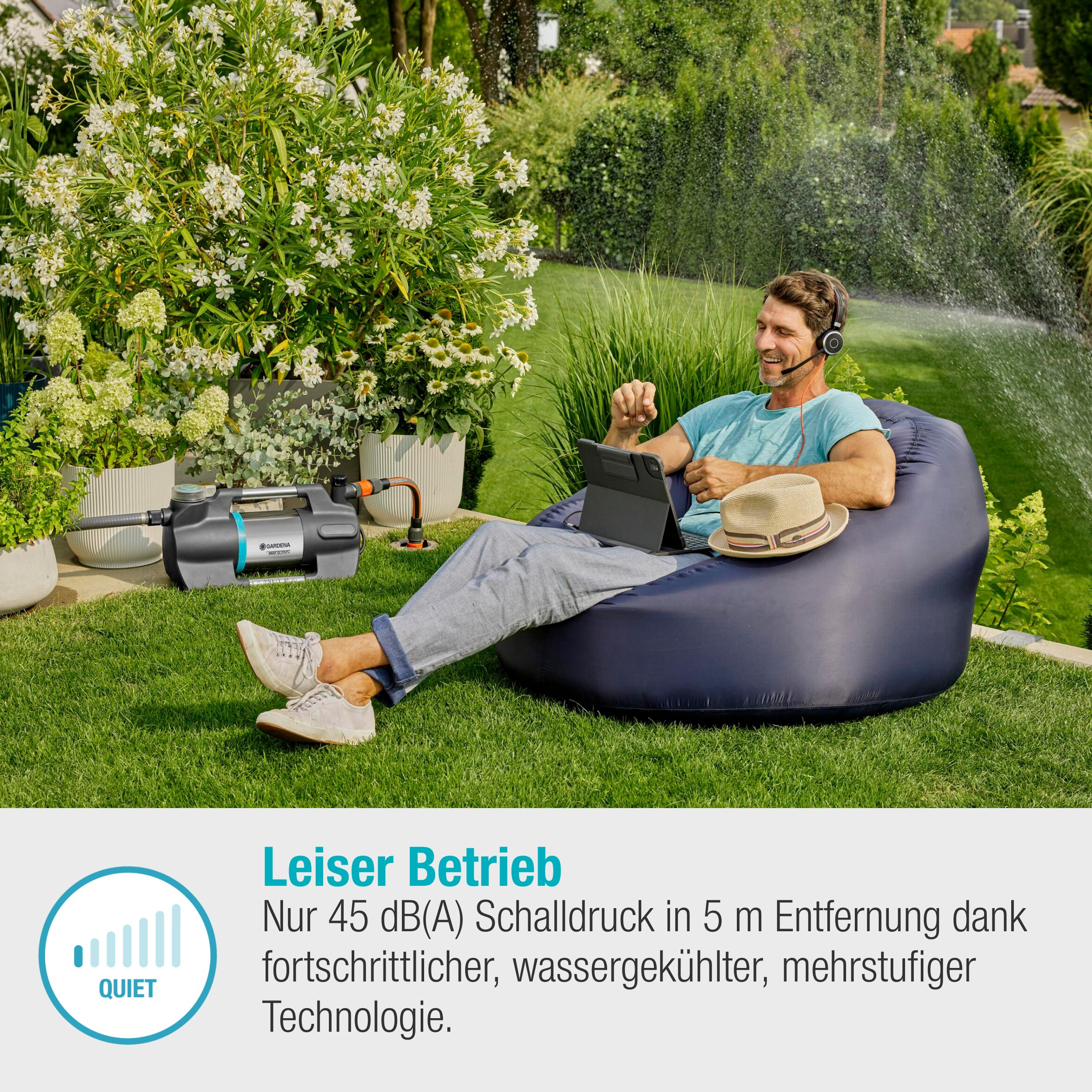 Mężczyzna w worku sako używający tabletu, z pompą wodną i ogrodem w tle.