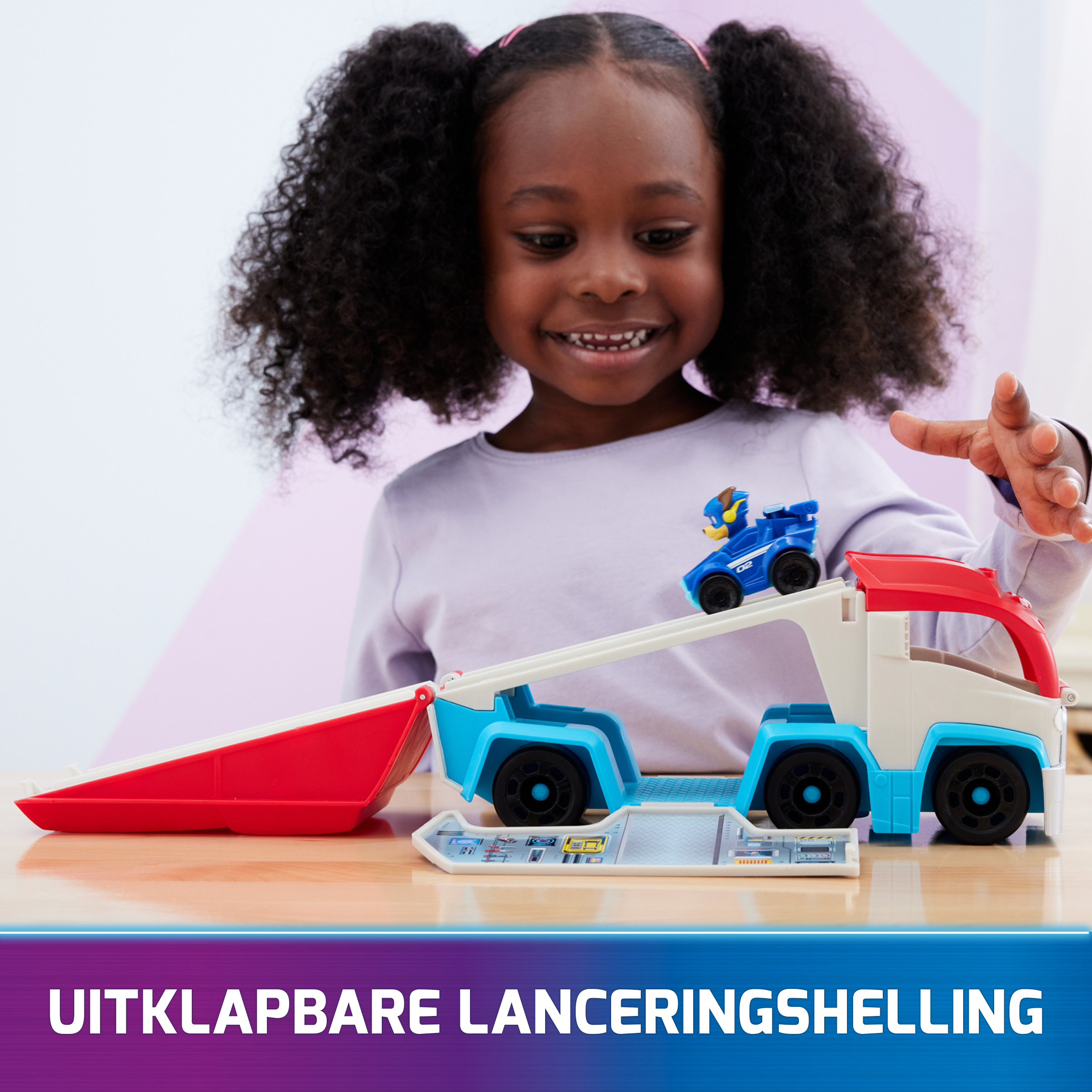 Una niña jugando con un camión de juguete que tiene una rampa.