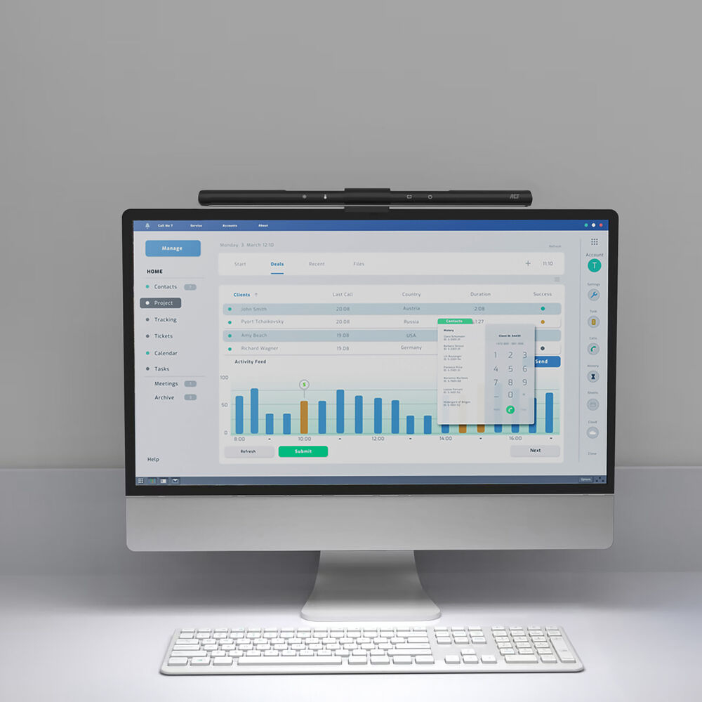 A computer monitor showing a business-related screen and a desk lamp.