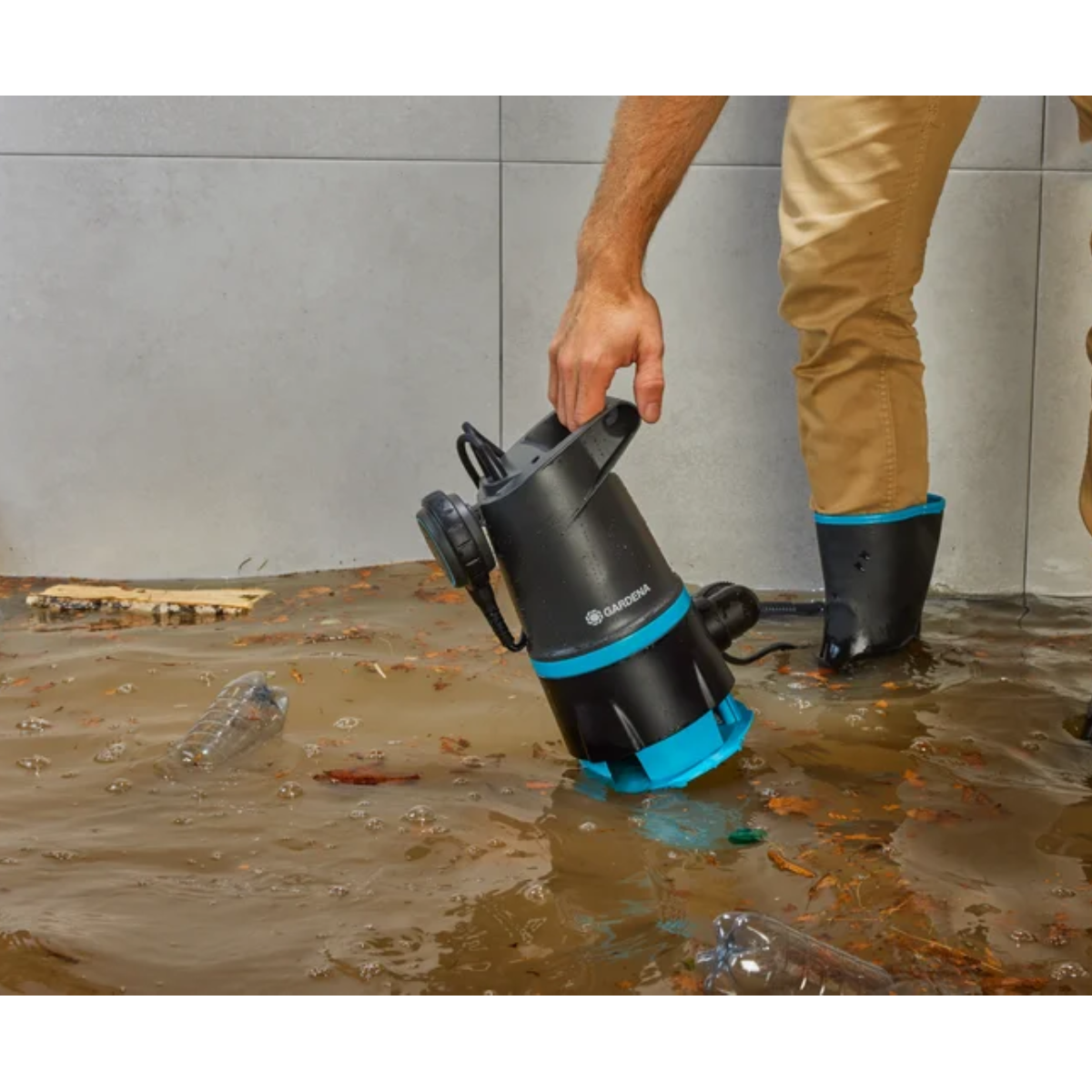 Osoba używająca czarno-niebieskiej pompy zanurzeniowej.