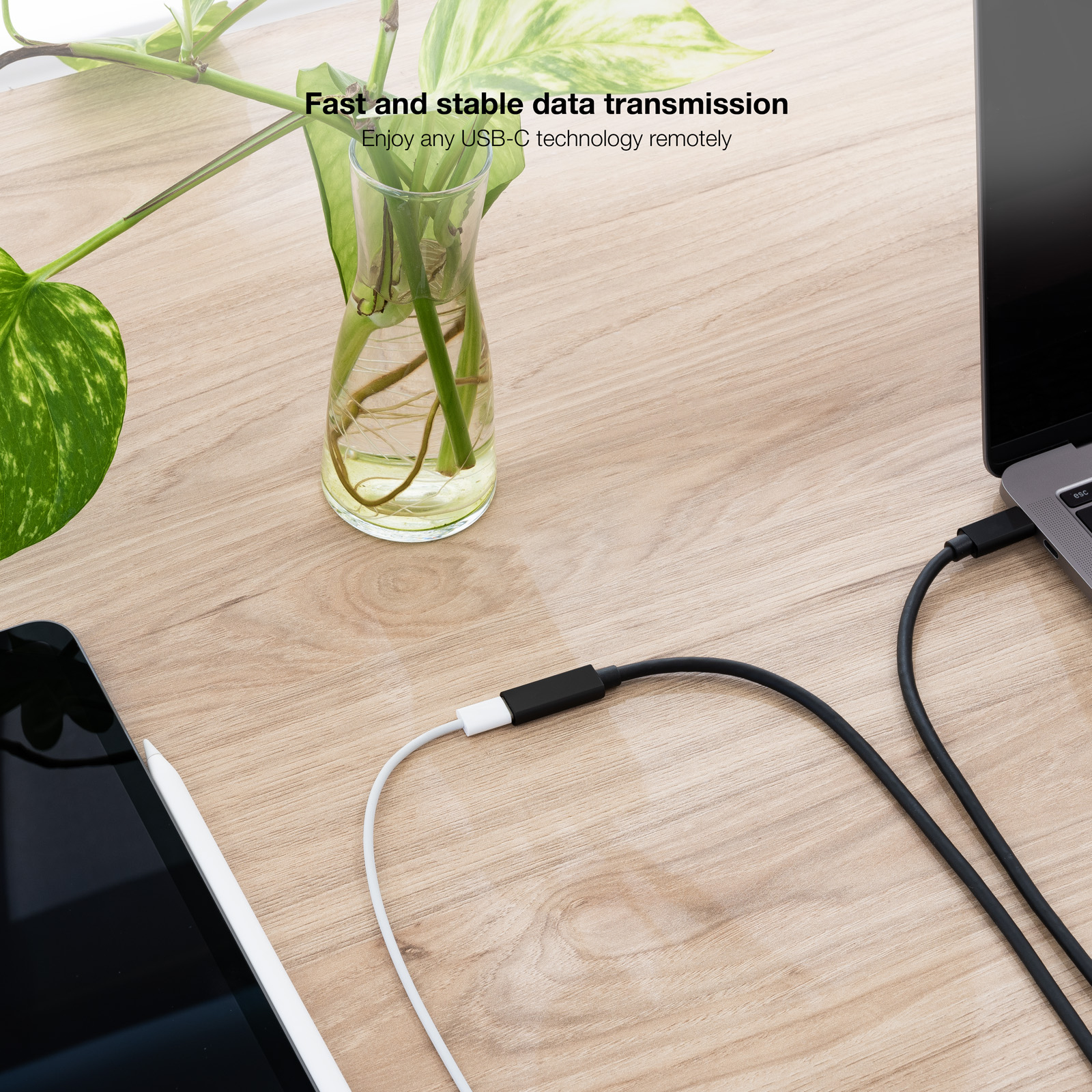 Tavolo con laptop, tablet e un cavo bianco che li collega. Il testo recita: Trasmissione dati veloce e stabile.