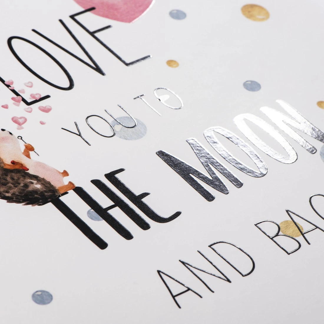 Kartka z napisem "Kocham cię aż do księżyca i z powrotem", ilustracją jeża i kształtami serca.