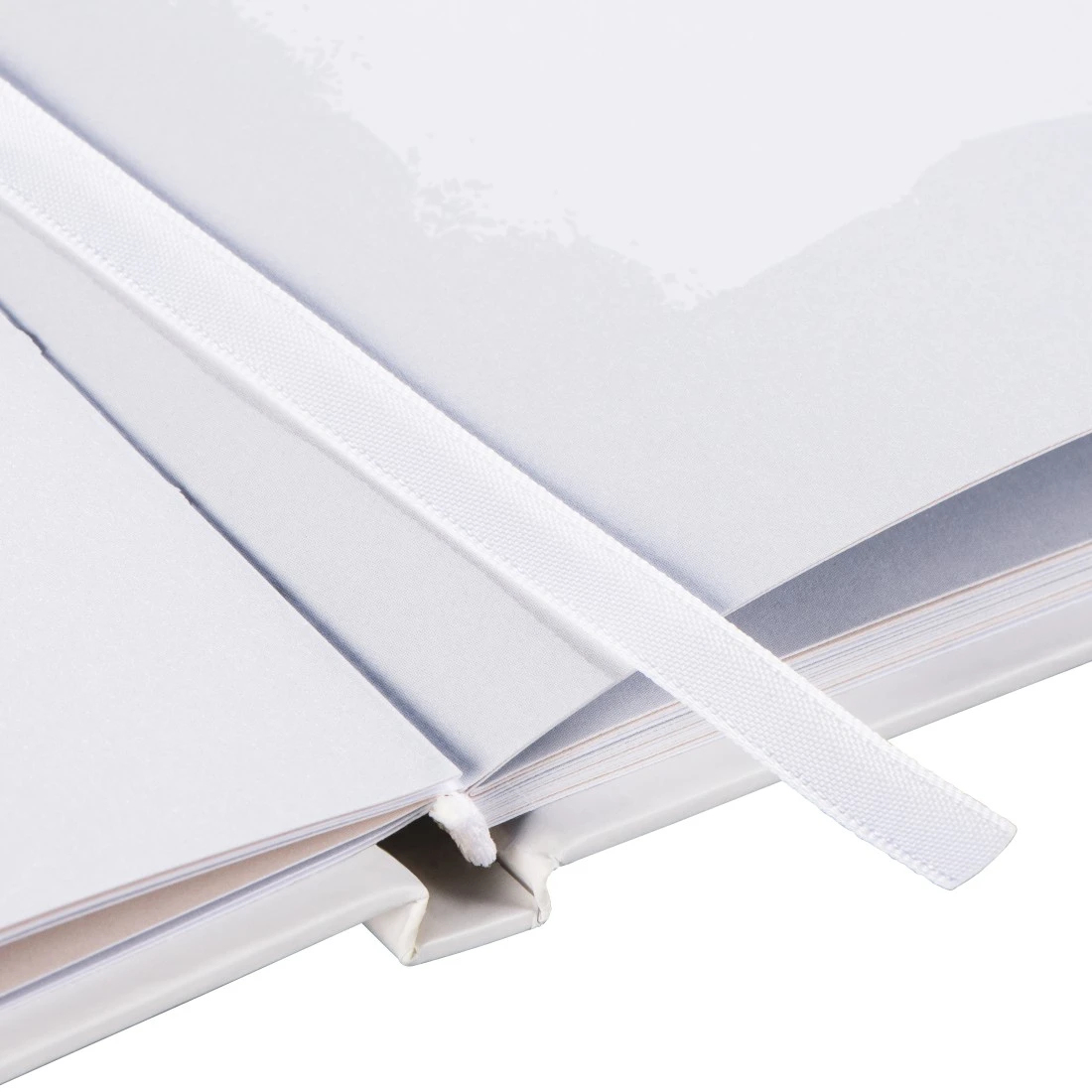 Otwarta biała książka z białą wstążką jako zakładką. Białe tło.