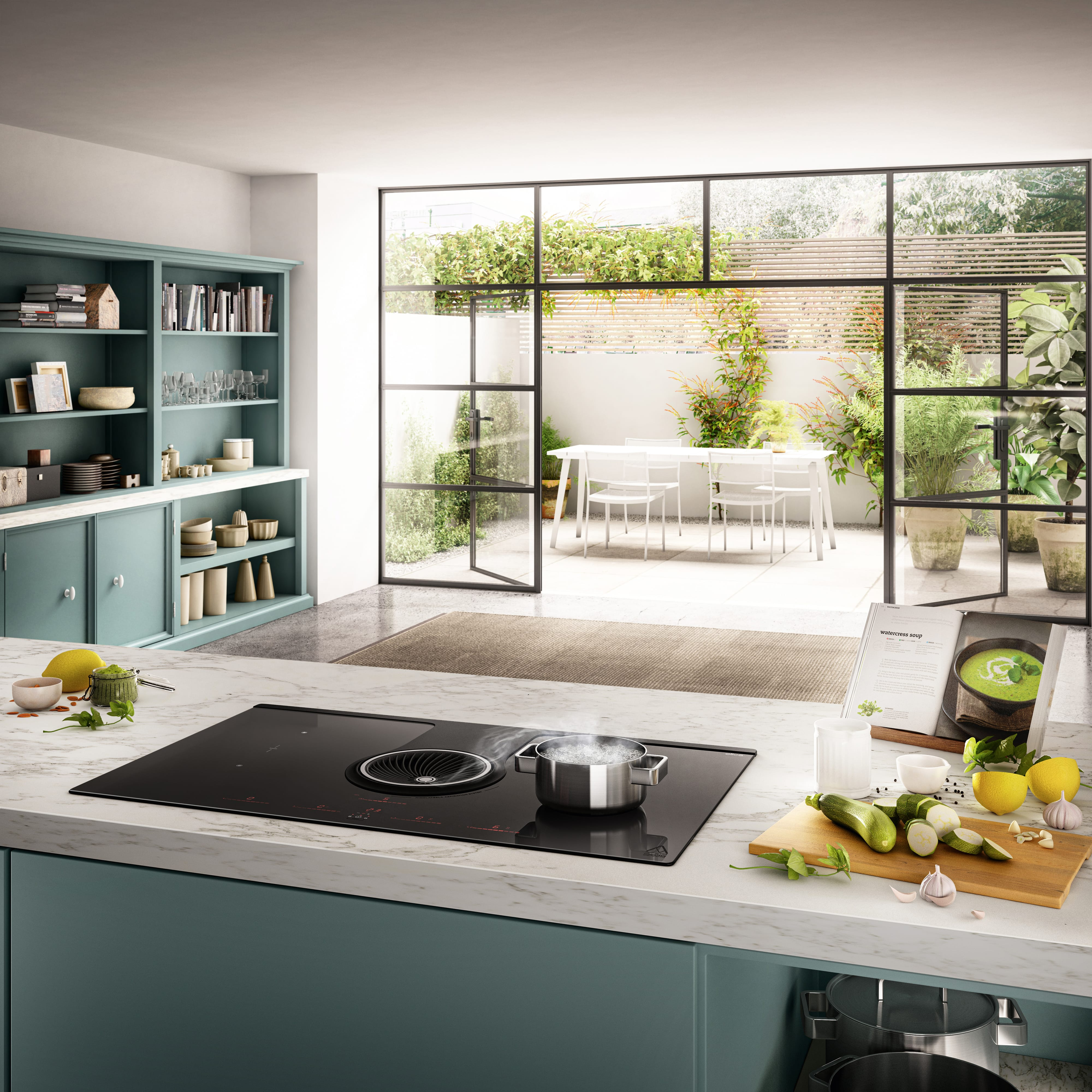 Cucina con isola, piano cottura e porte aperte sul giardino. Ingredienti sul bancone.