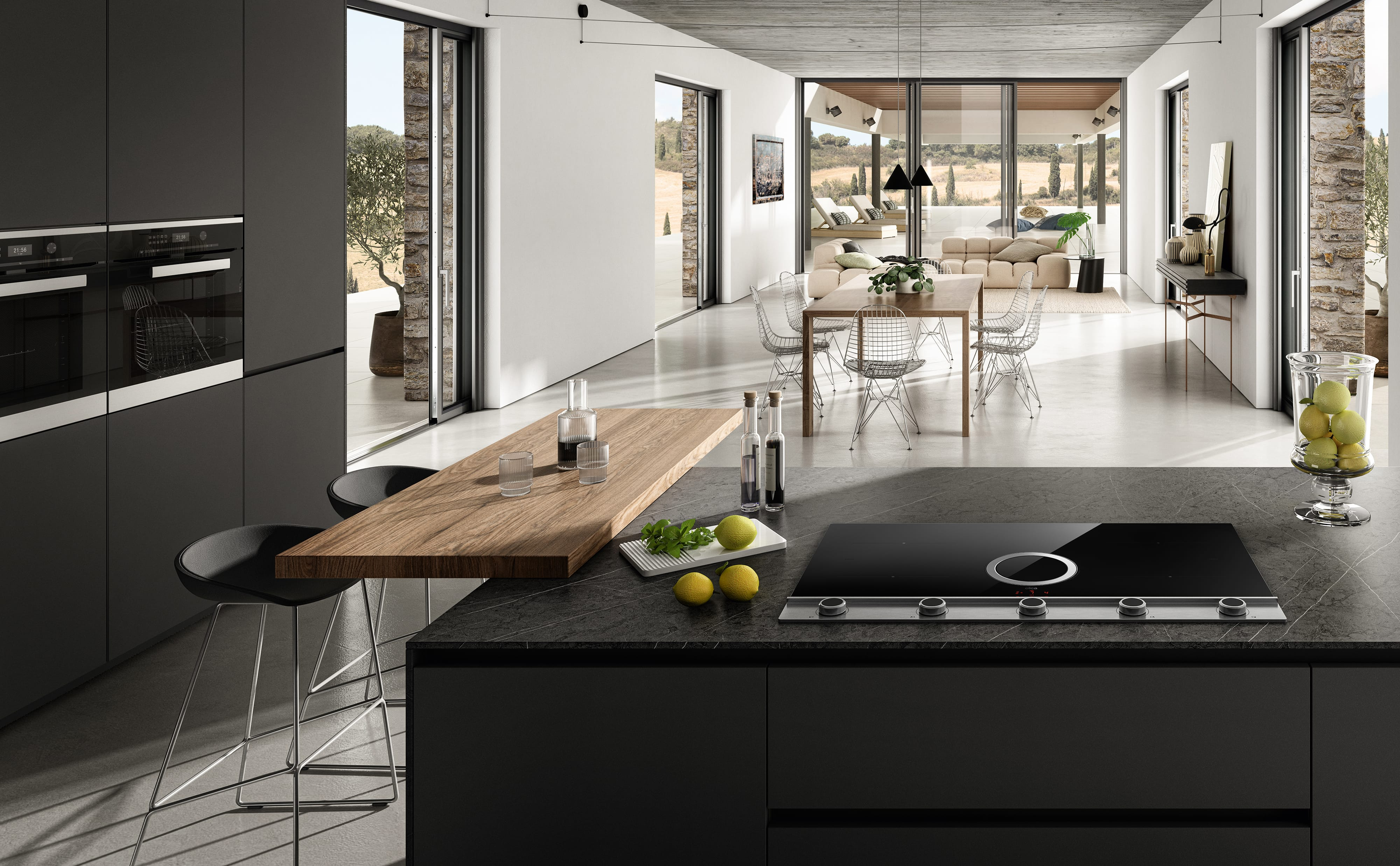 Interni cucina moderna con mobili grigio scuro, piano lavoro in legno e piano cottura nero.