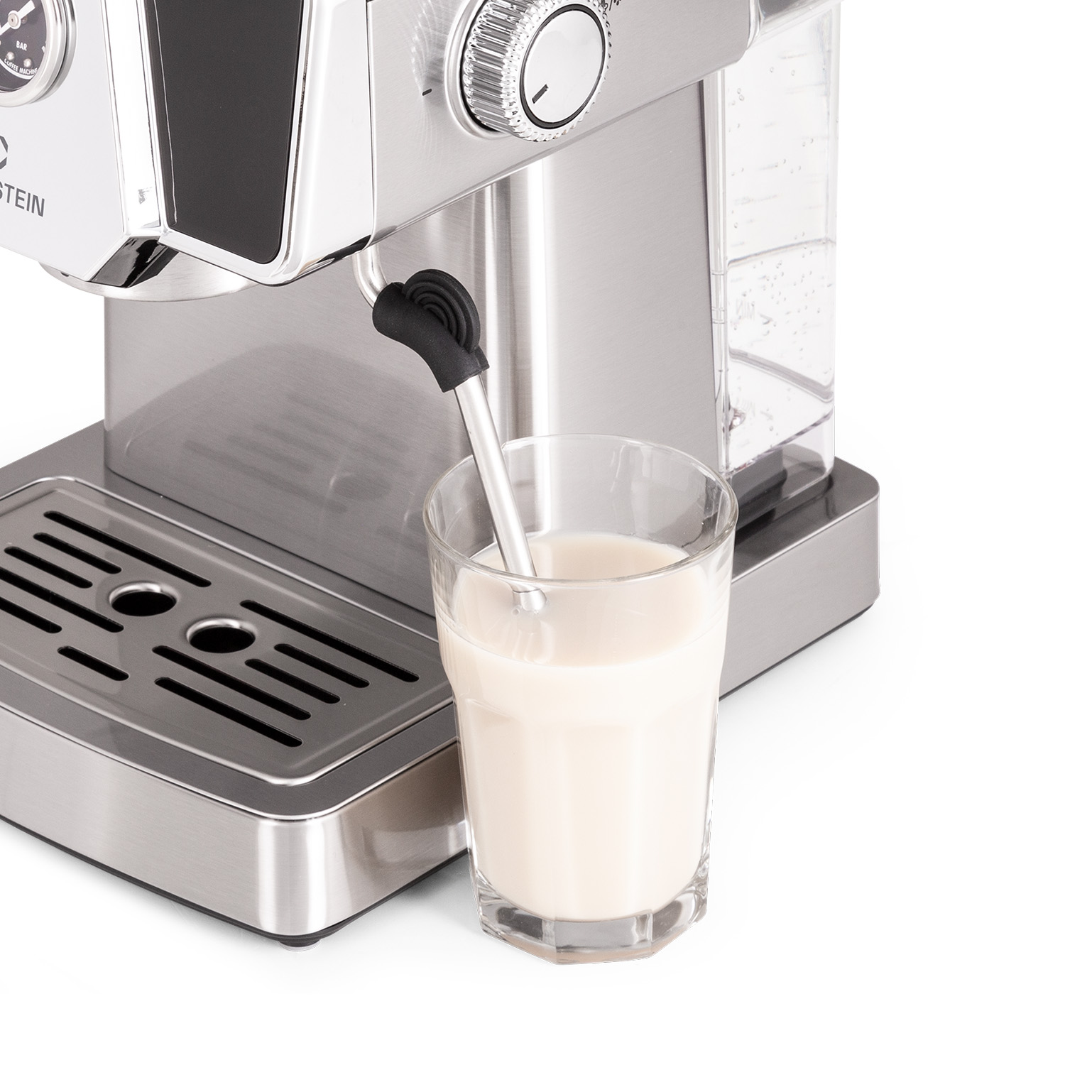 Máquina de espresso con un vaso de leche y una cuchara de metal.