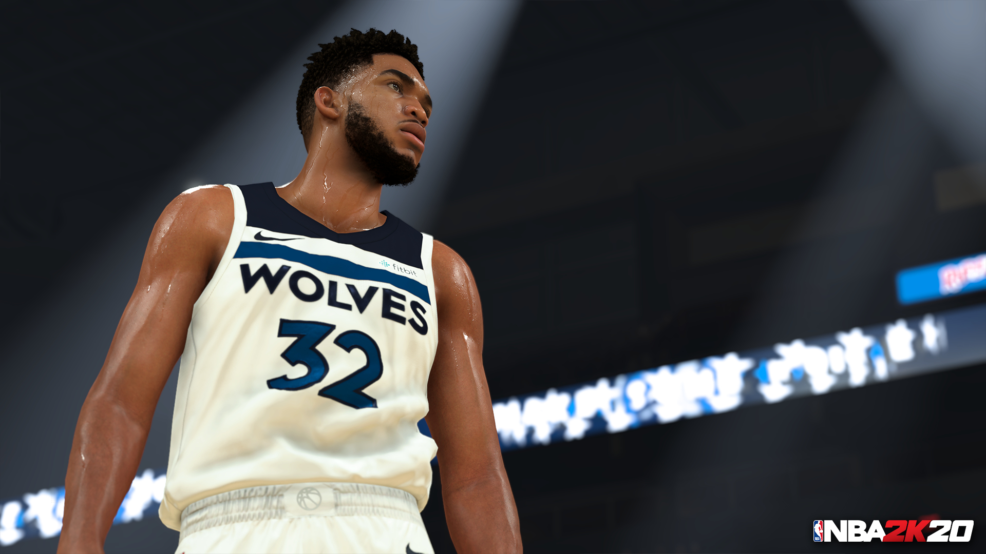 Giocatore di basket con maglia bianca con logo Wolves, che guarda in alto, su un campo illuminato.