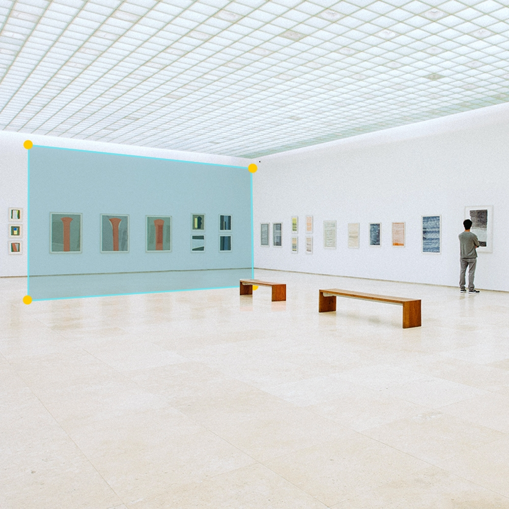 Interno di una galleria d'arte con opere d'arte sul muro. Una persona guarda l'arte.