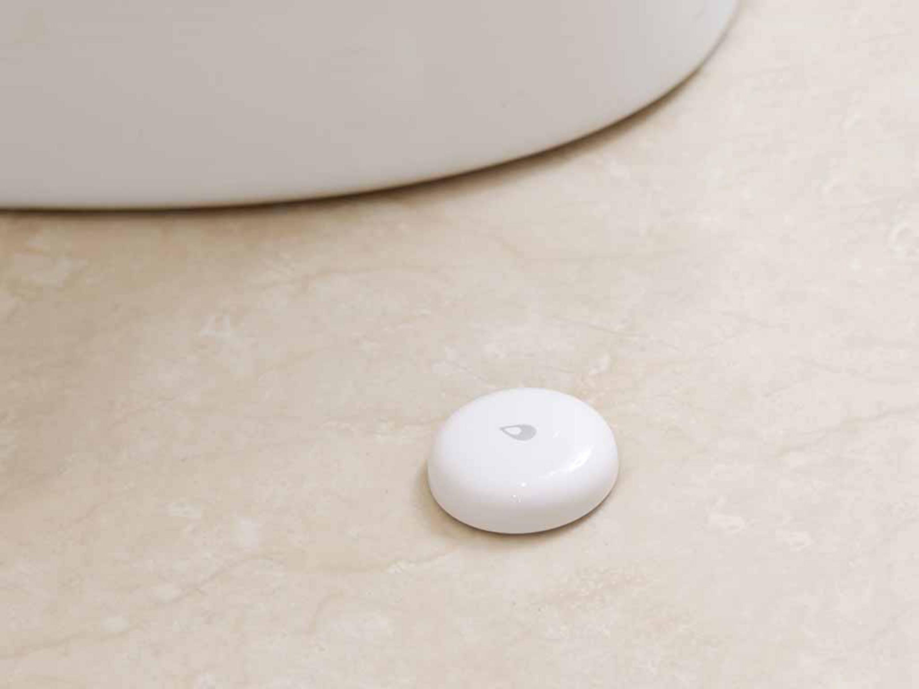 Biały, okrągły czujnik wody z ikoną kropli.