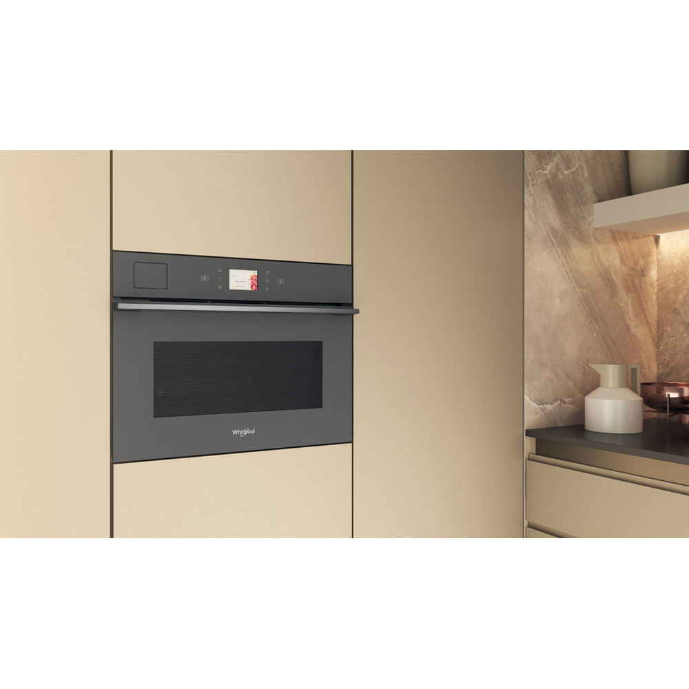 Forno a microonde da incasso grigio scuro in una cucina.