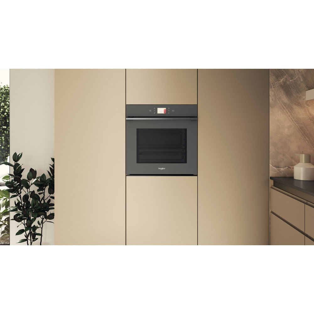 Forno nero da incasso in un ambiente cucina, circondato da mobili beige.