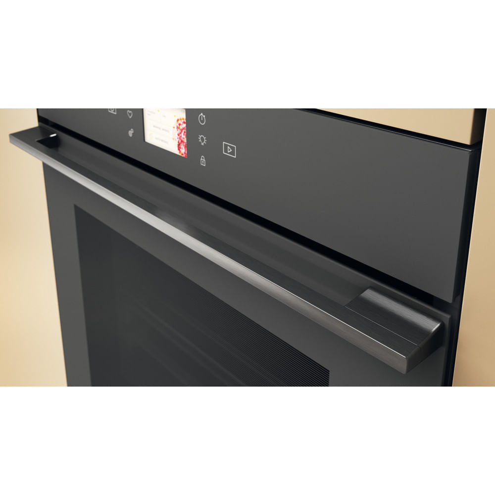 Primo piano della maniglia nera del forno con touchscreen integrato.