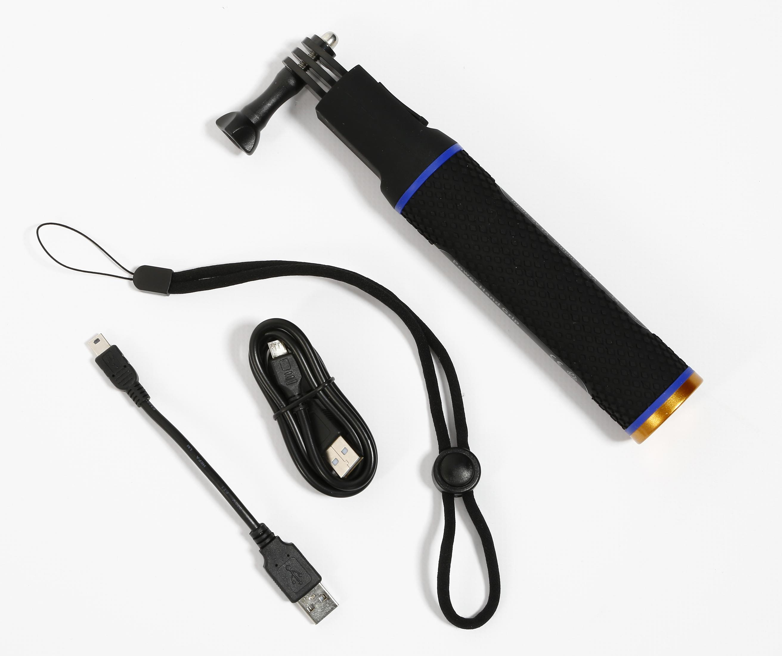 Uchwyt do aparatu, kabel ładujący i pasek na nadgarstek leżą na białej powierzchni. Wszystkie elementy są czarne.