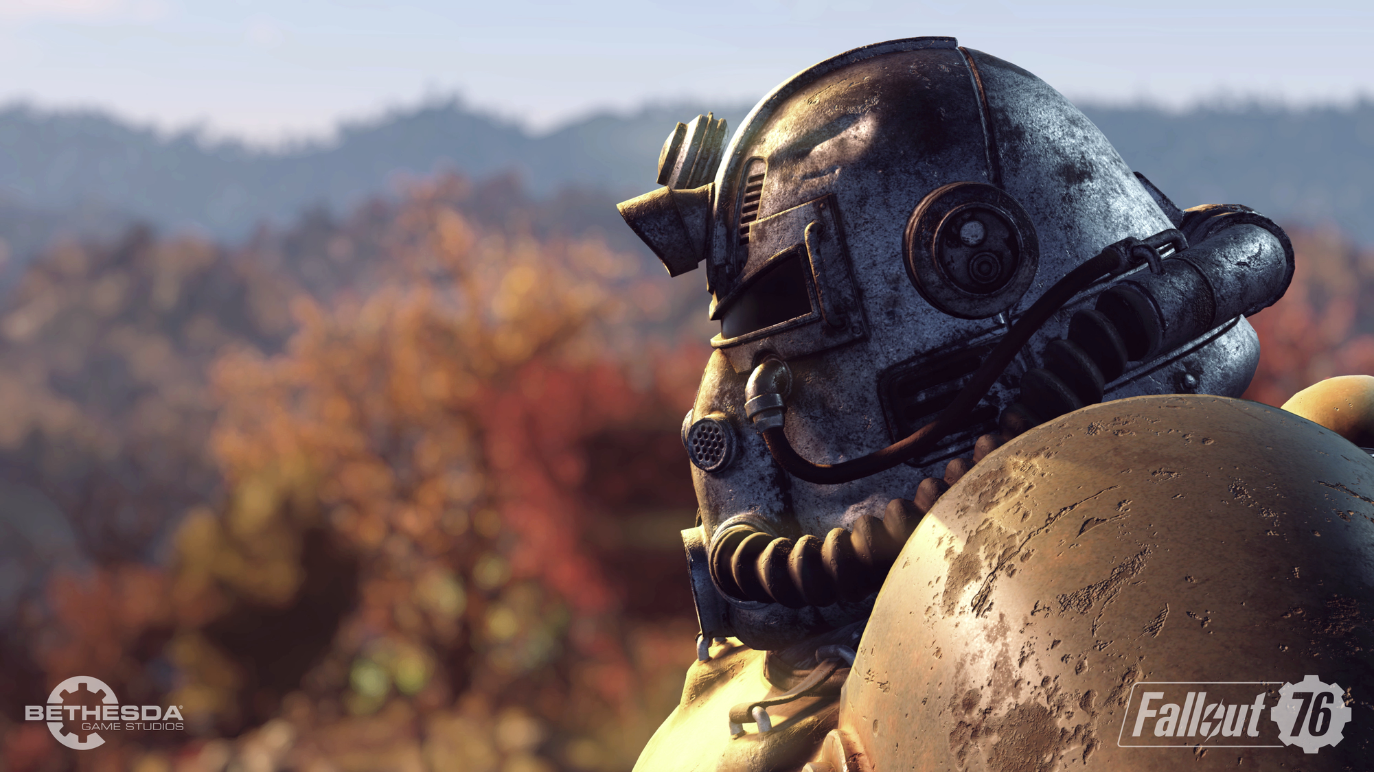 Postać z Fallout 76 w hełmie. Rozmyte tło krajobrazu jesiennego.