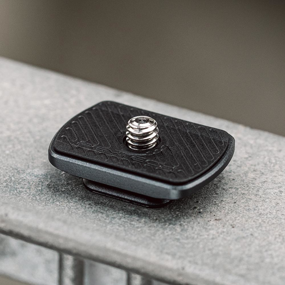 Zbliżenie czarnej płytki aparatu zamontowanej na szarej powierzchni.