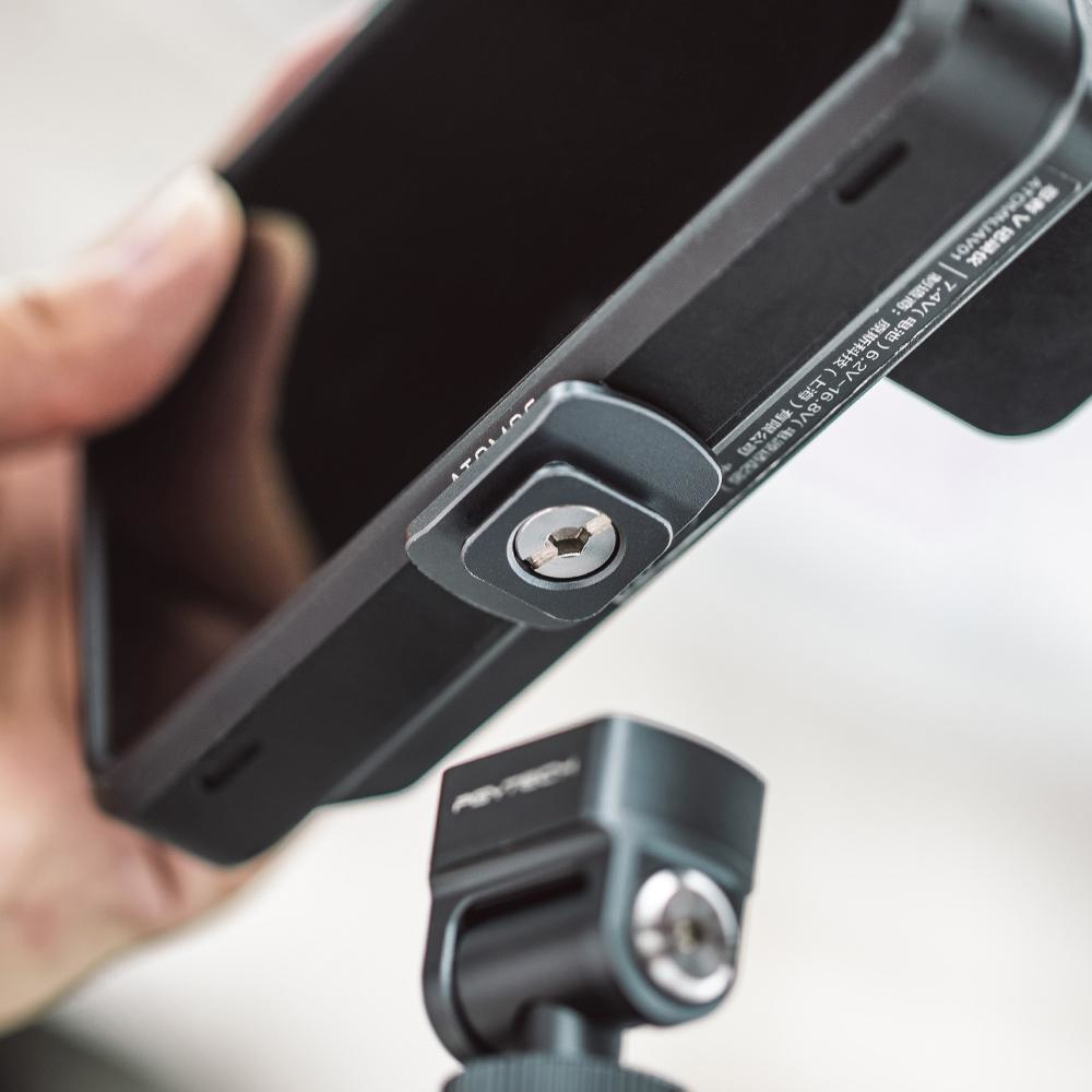 Telefon przymocowany do uchwytu na statywie, zbliżenie połączenia śrubowego.