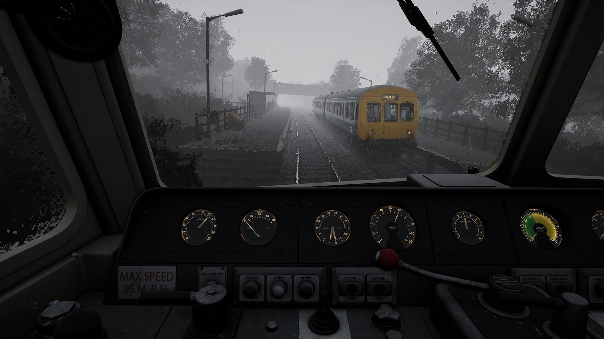 Vista cabina treno, treno giallo sui binari nella nebbia. Indicatori e comandi visibili. Cielo coperto.
