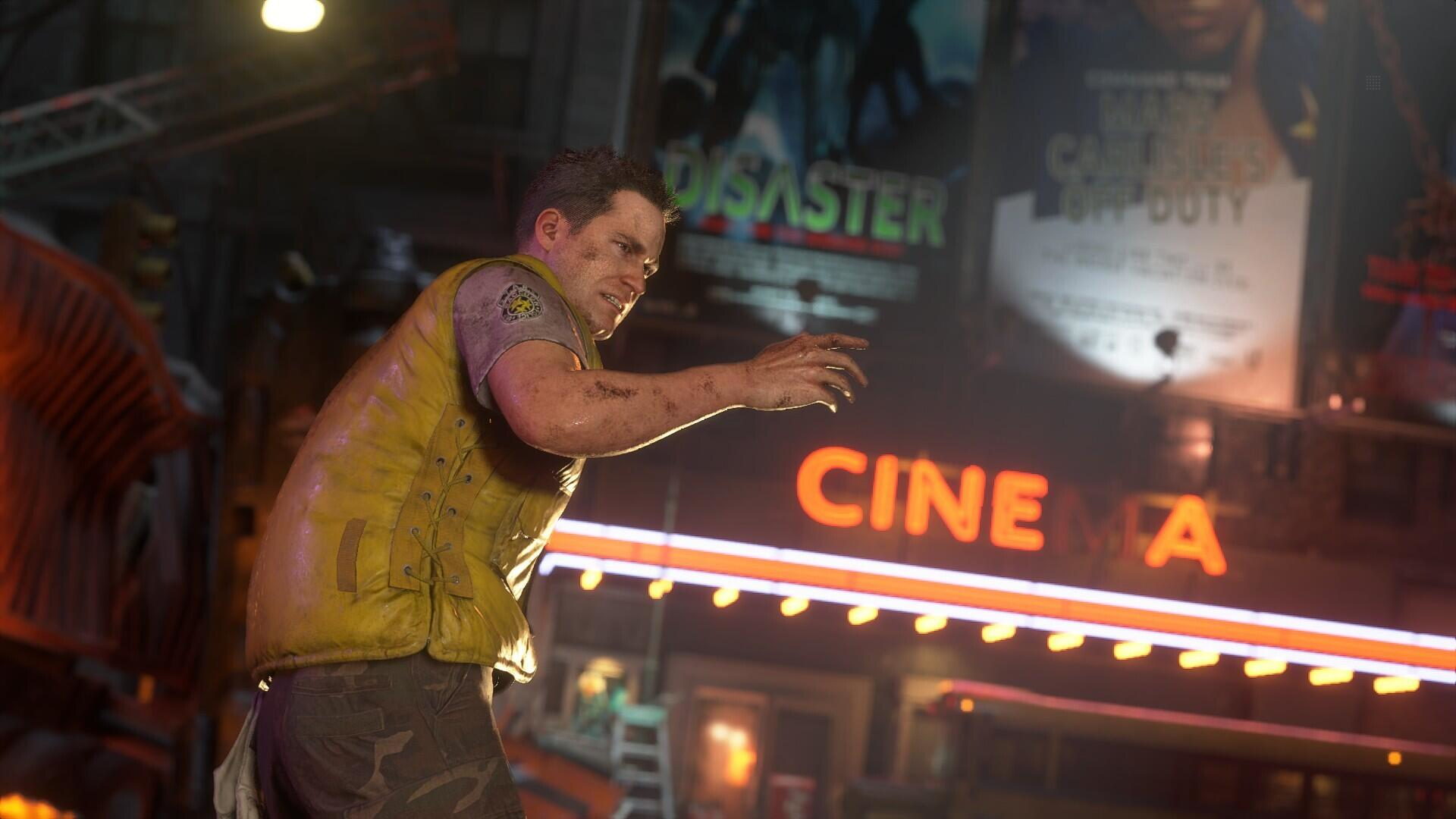 Mężczyzna w żółtej kamizelce patrzy w kamerę, stojąc przed kinem z neonami.