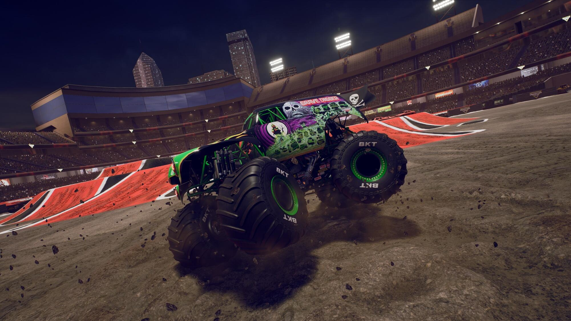 Monster truck na wzgórzu ziemnym na stadionie. Samochód ciężarowy jest zielony i fioletowy.