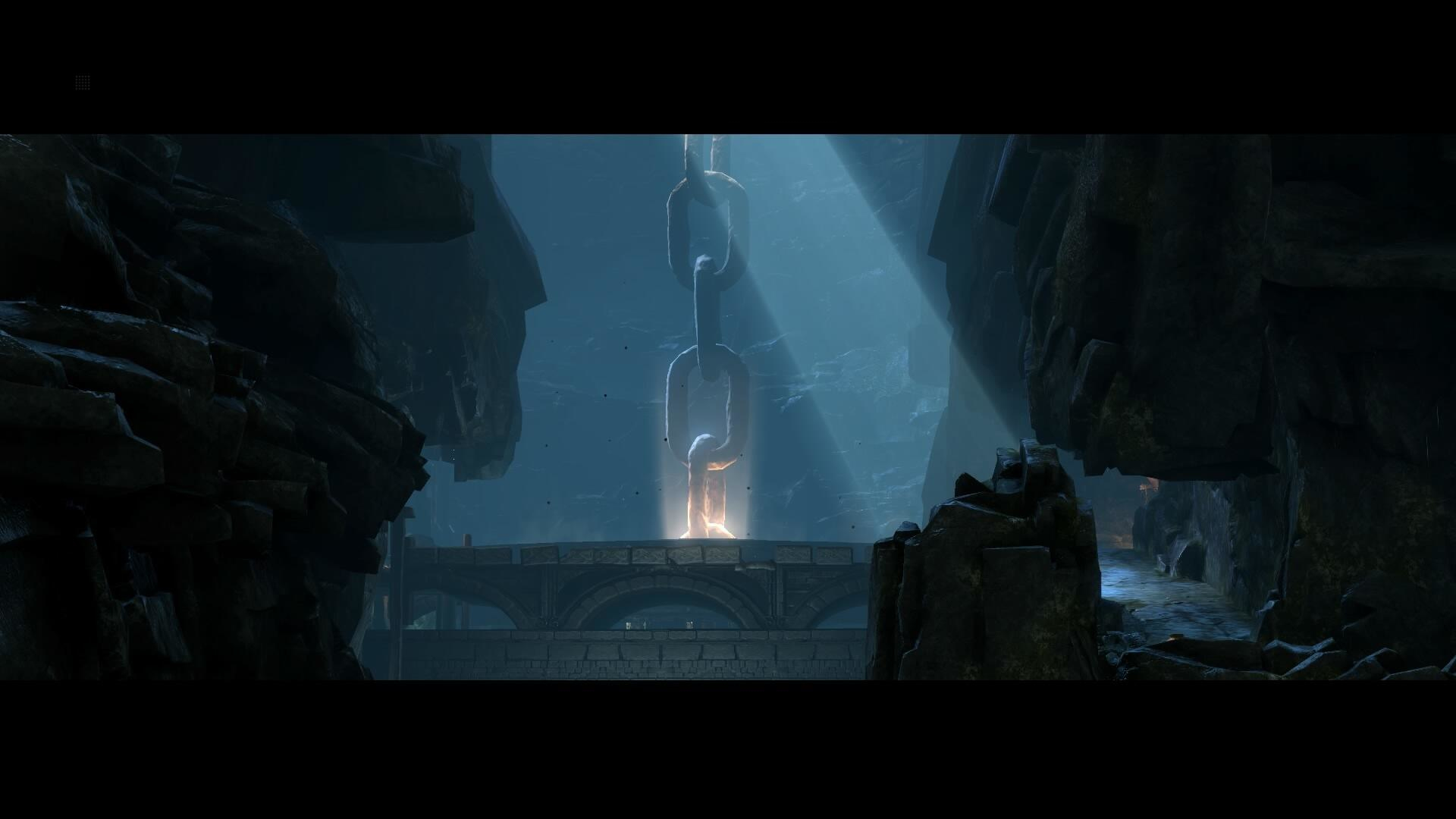 Kamienny most w jaskini z wiszącym łańcuchem. Światło oświetla łańcuch.