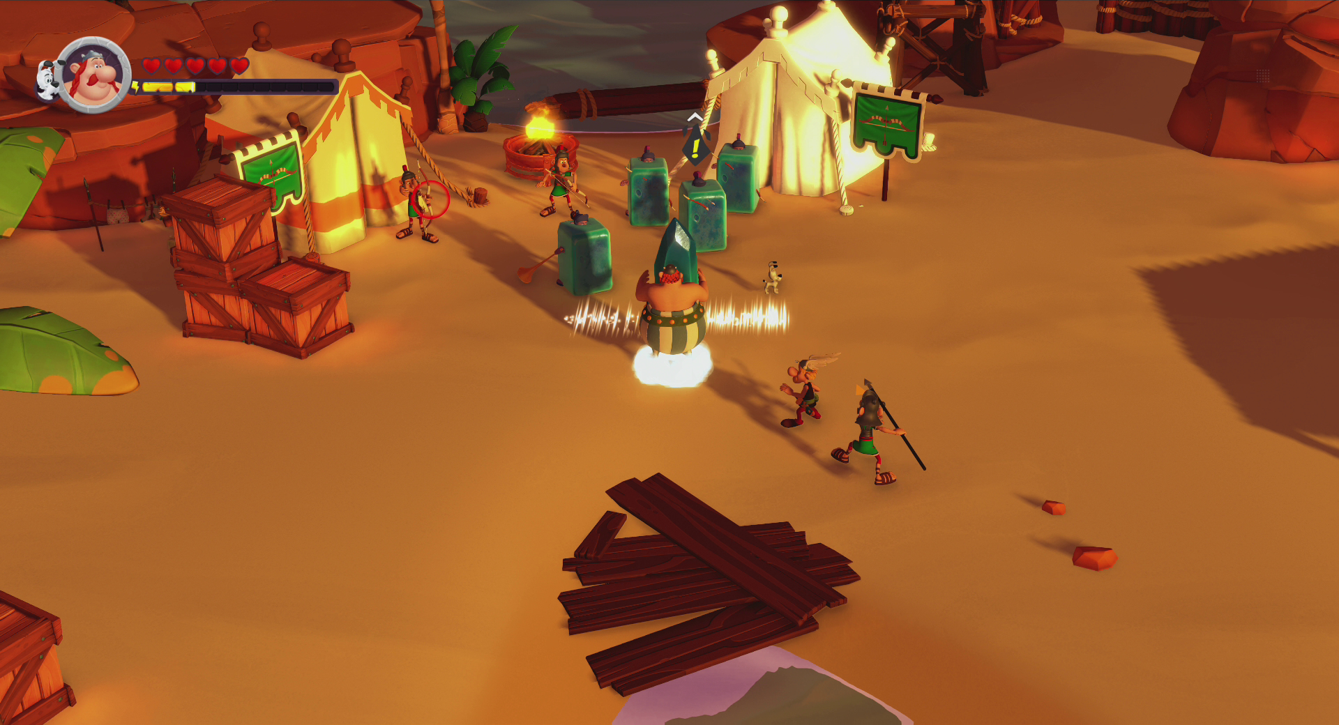 Scena del gioco Asterix. Personaggi in un ambiente desertico. Casse di legno, tende e una luce intensa.