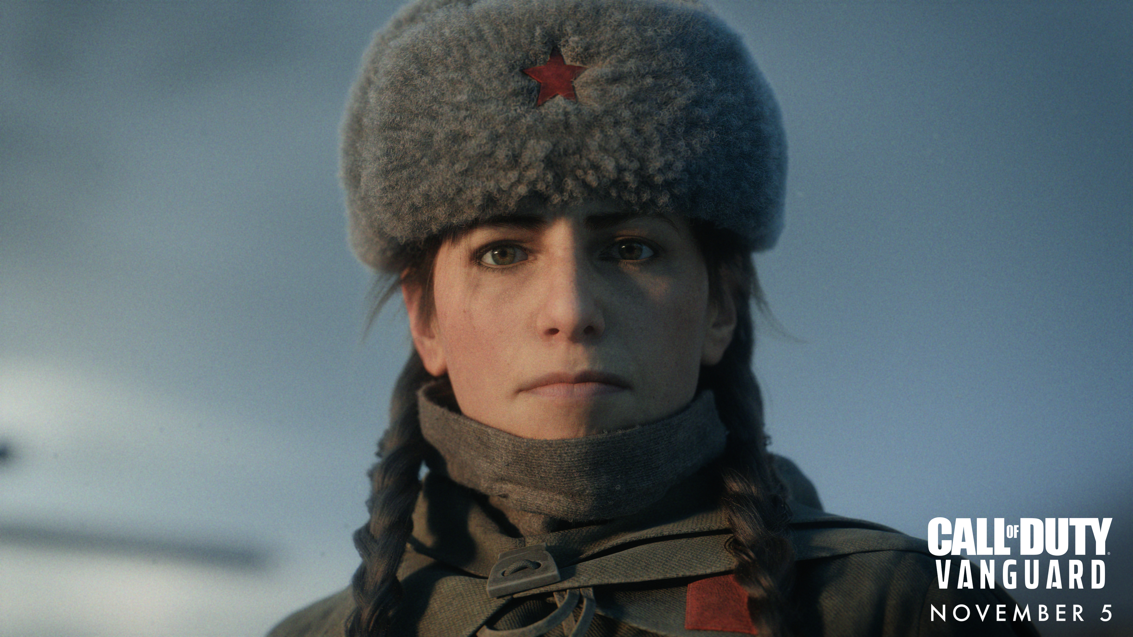 Una donna con trecce e un cappello di pelliccia. Indossa un'uniforme militare e guarda lo spettatore con un'espressione seria.
