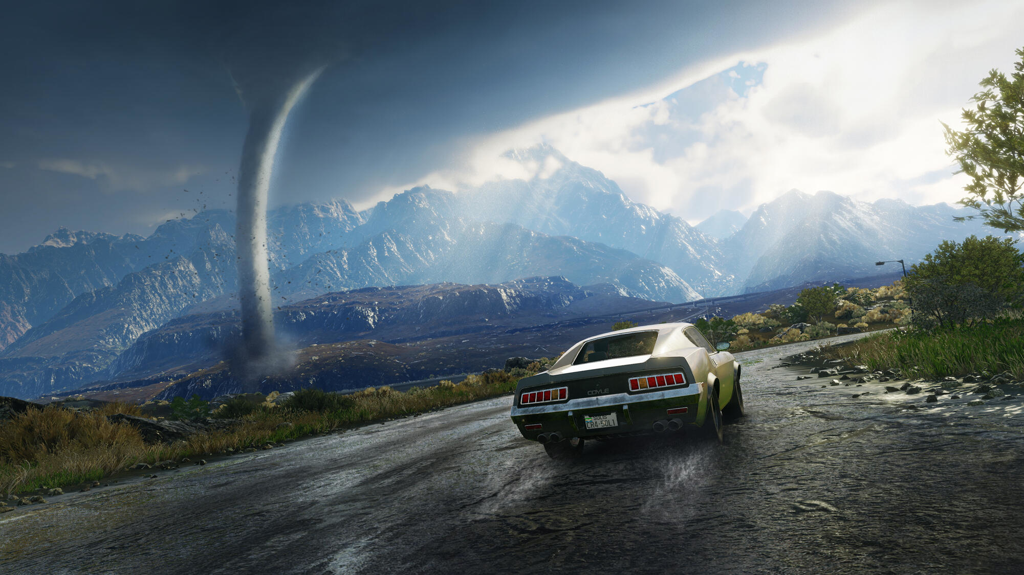 Un'auto guida su una strada con un tornado e montagne sullo sfondo, sotto un cielo nuvoloso.