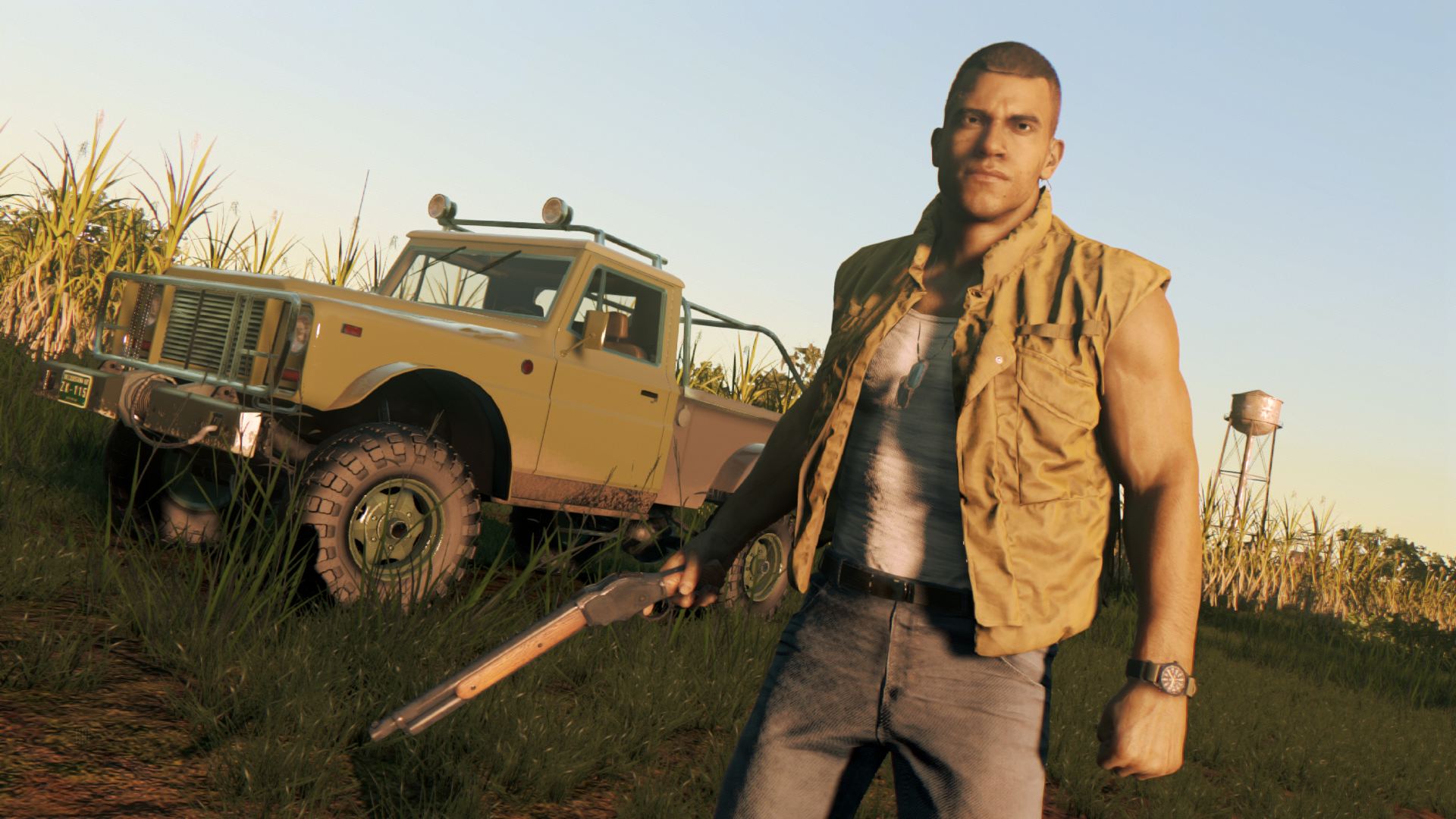 Mężczyzna z karabinem i ciężarówką na polu. Ma na sobie kamizelkę. Wysoka trawa i zbiornik na wodę w tle.