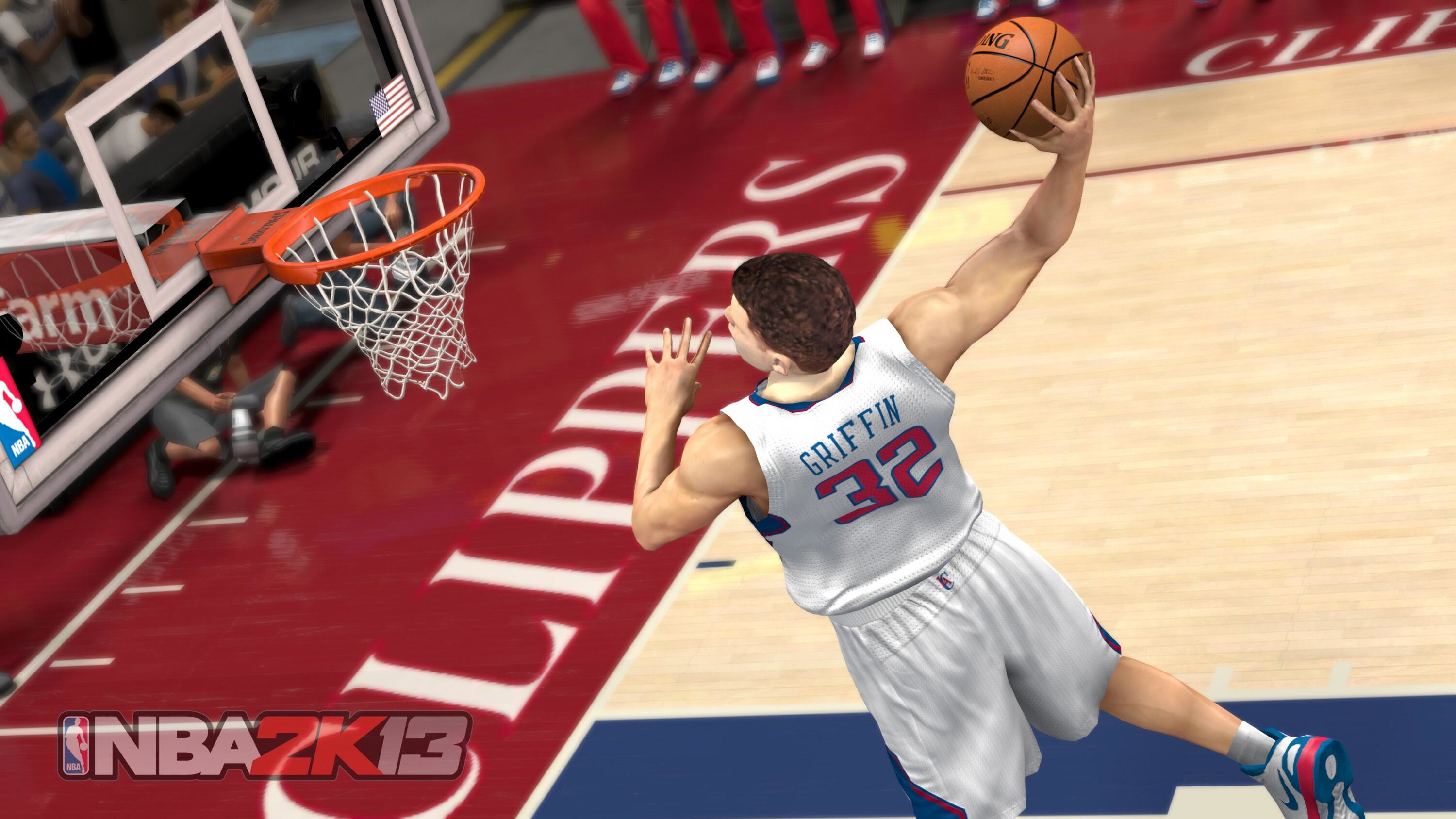 Koszykarz w białej koszulce wbija piłkę do kosza. Tłum patrzy. Logo NBA 2K13 w rogu.