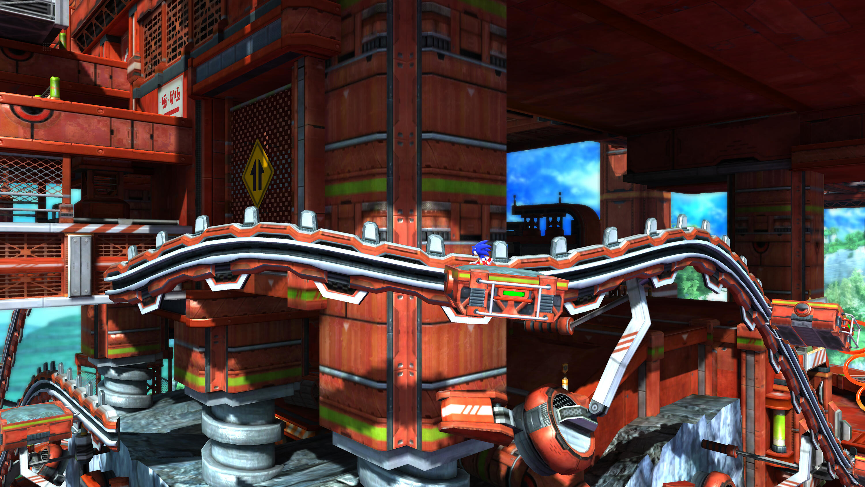 Scena del gioco Sonic. Sonic è su un ponte in un ambiente rosso e metallico. Cielo blu sullo sfondo.