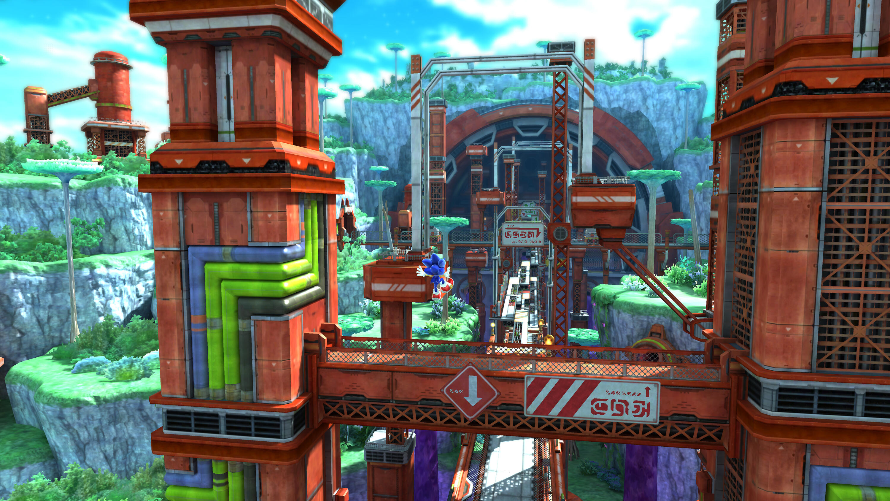Sonic the Hedgehog che corre su un ponte in un ambiente futuristico e colorato con formazioni rocciose.