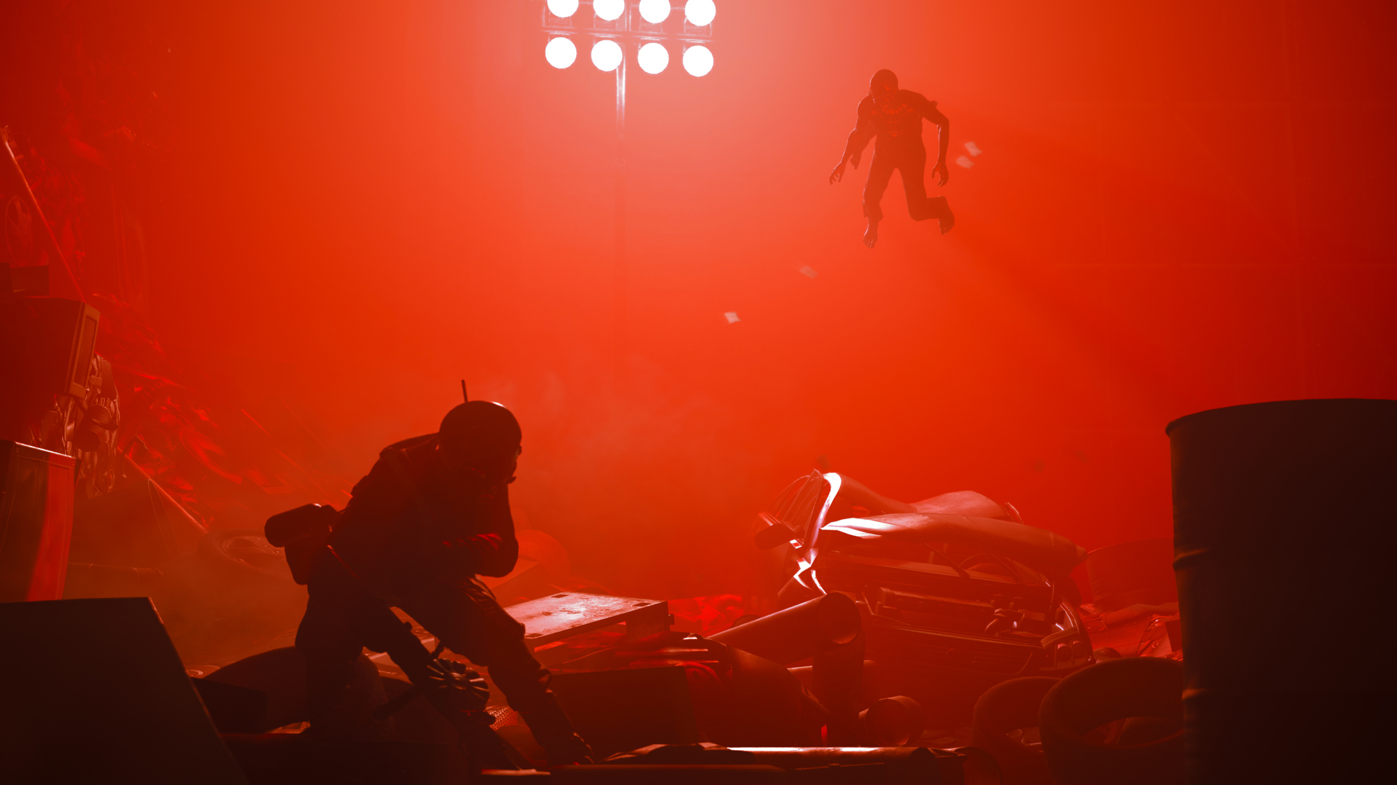 Dwie sylwetki, jedna celuje z broni. Jasnoczerwone tło z rozrzuconymi odłamkami.