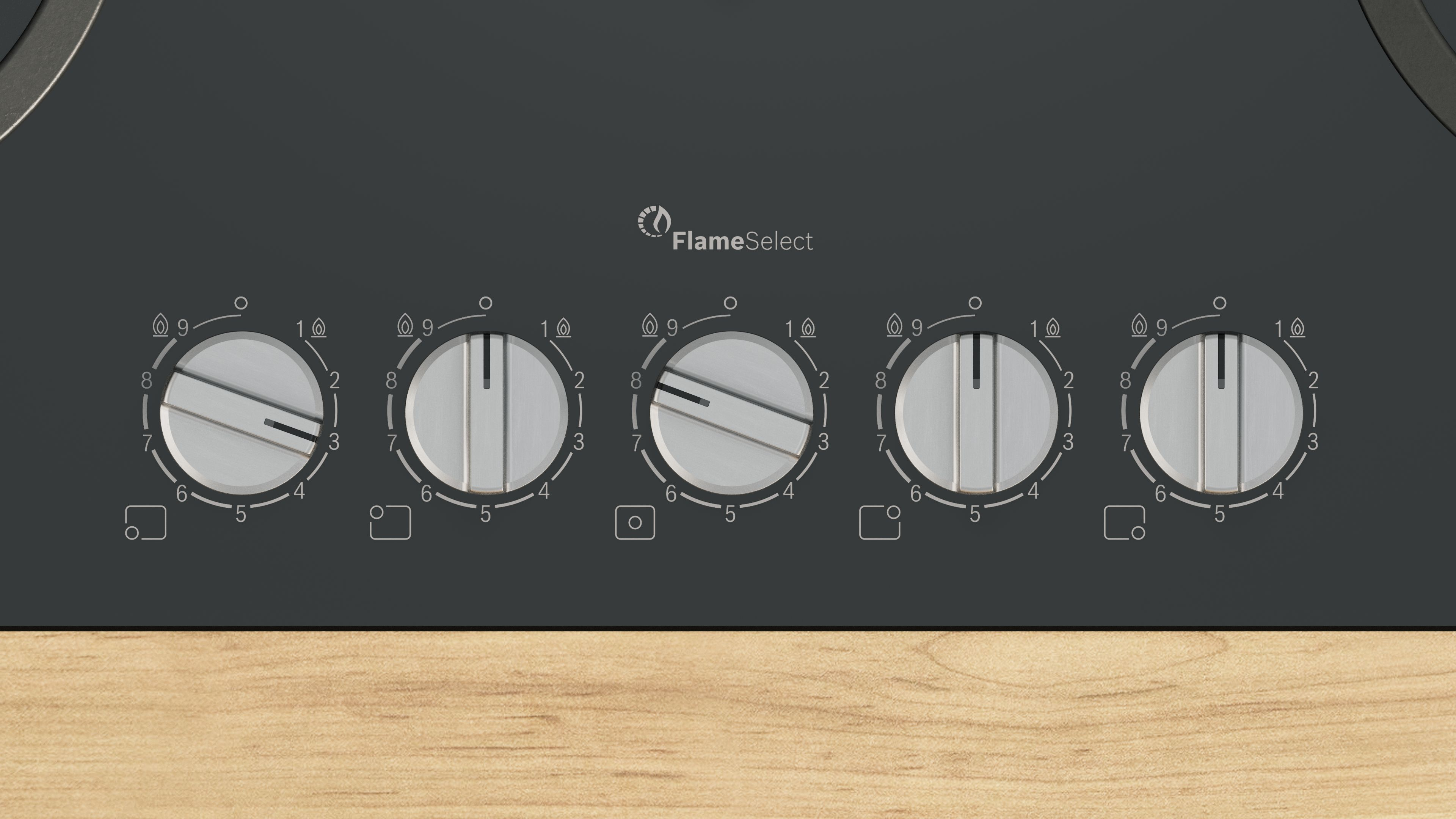 Pokrętła sterowania płyty gazowej z numerami i logo FlameSelect na drewnianej powierzchni.