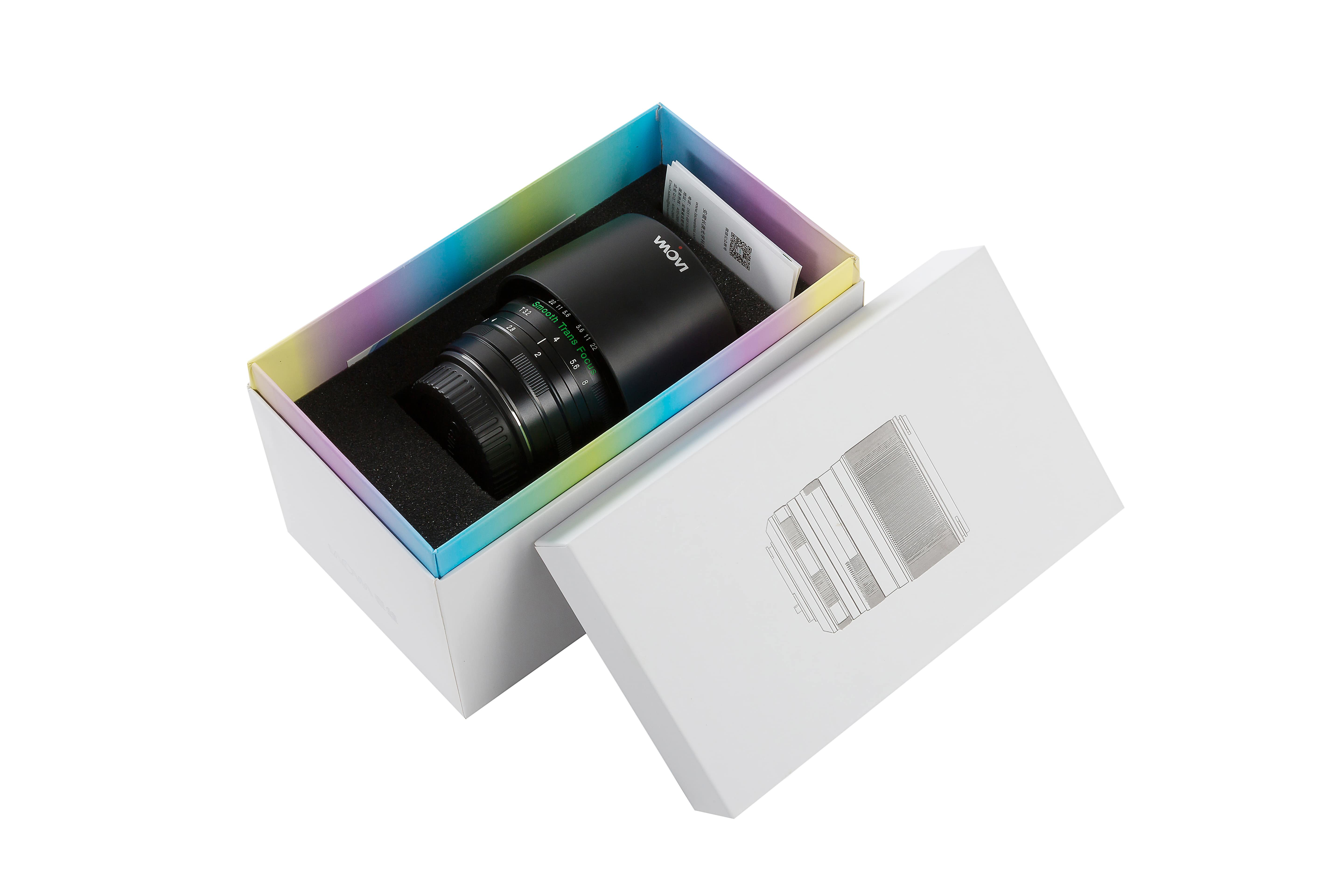 Obiektyw aparatu w pudełku, z tęczowym wnętrzem i otwartą pokrywą.