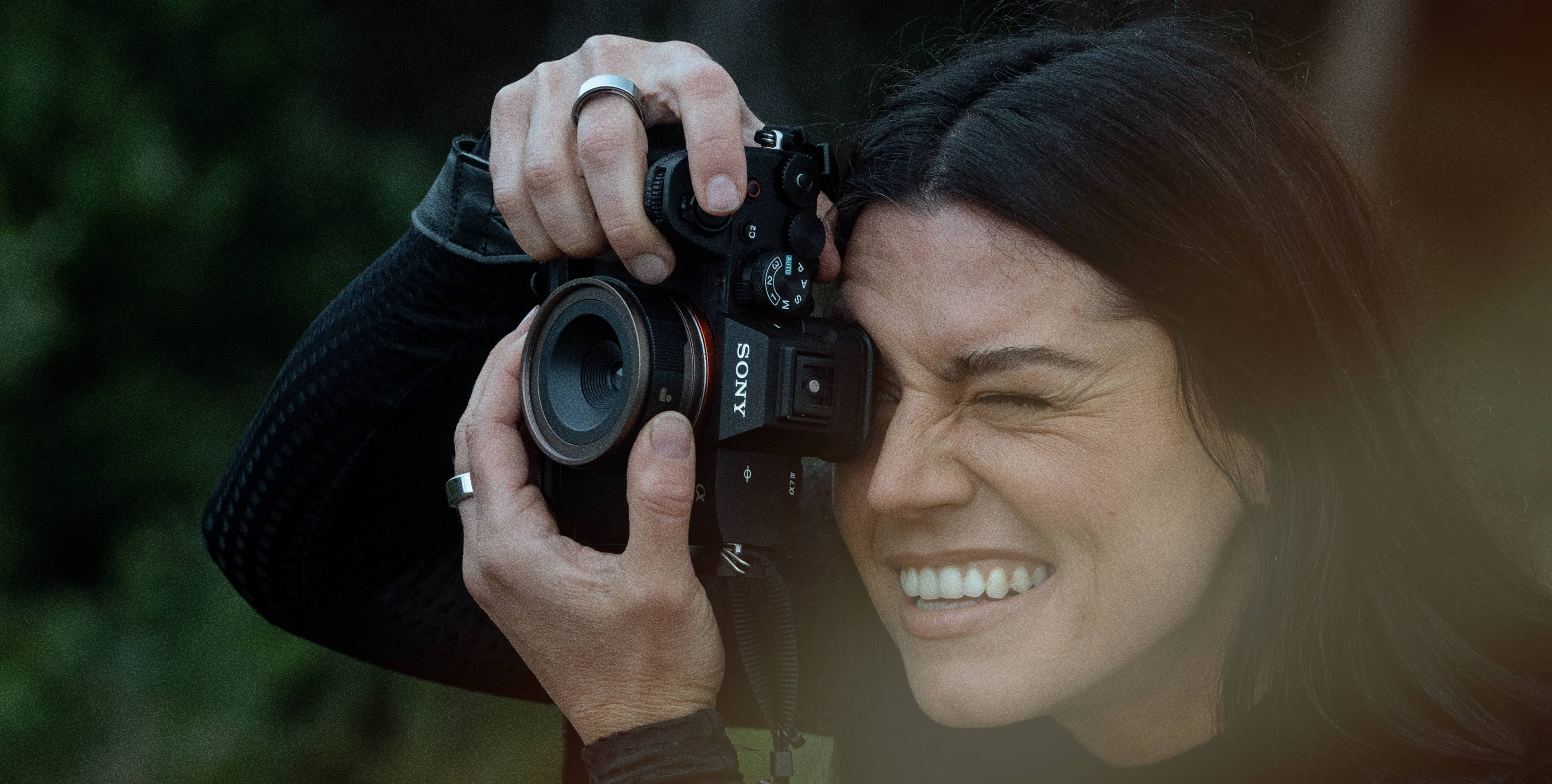 Kobieta uśmiecha się, robiąc zdjęcie aparatem Sony. Zbliżenie.