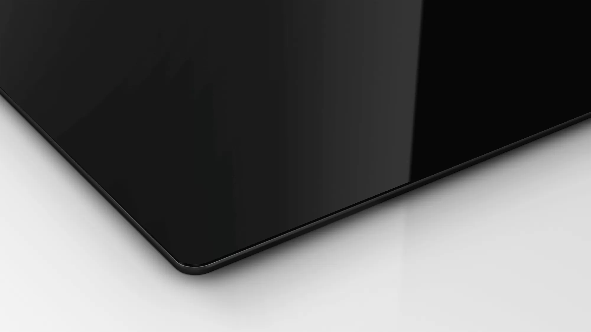 Une surface en verre noir avec un fond blanc et une vue légèrement angulaire.