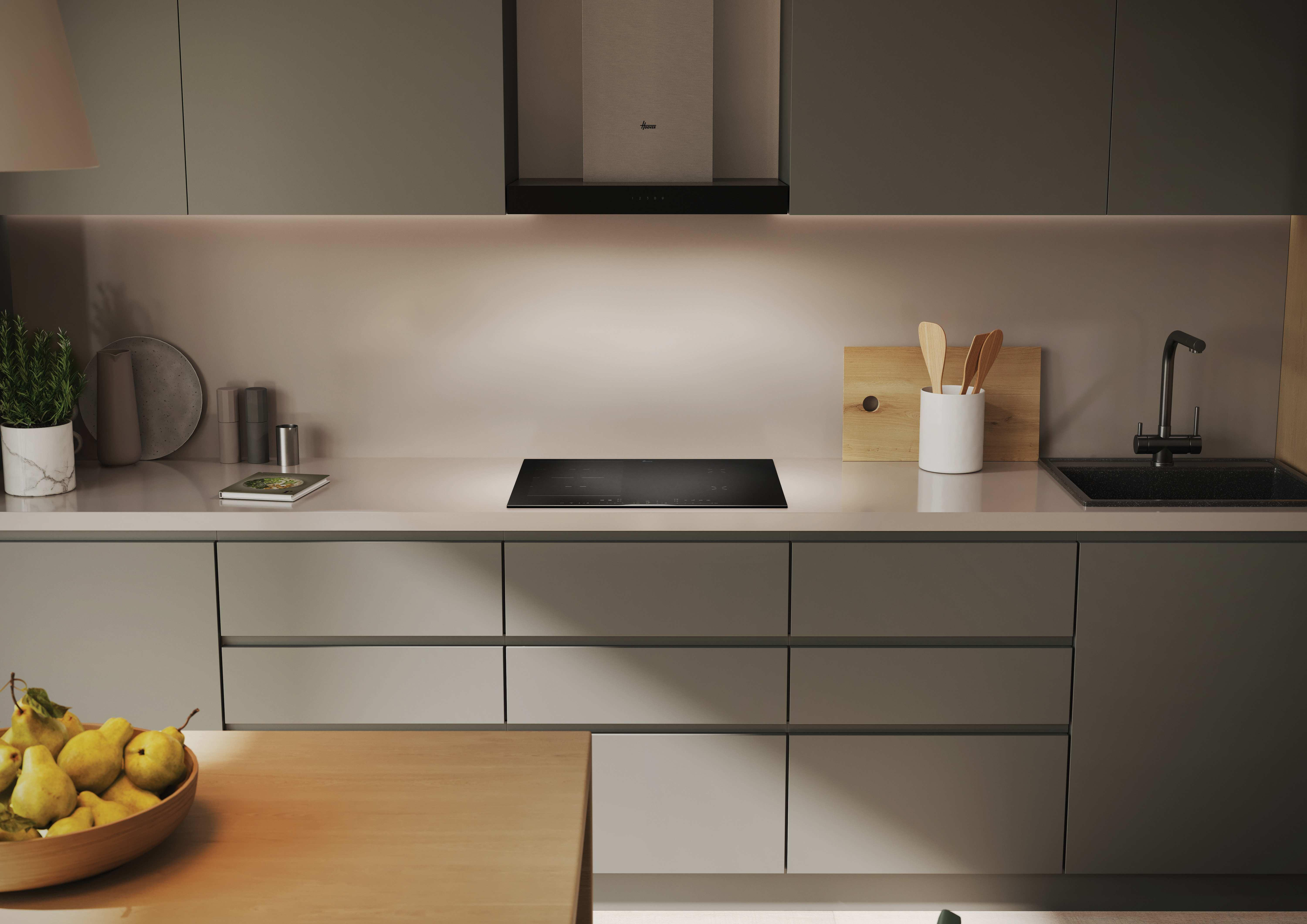 Una cucina moderna con un piano cottura a induzione integrato e un piano di lavoro chiaro.