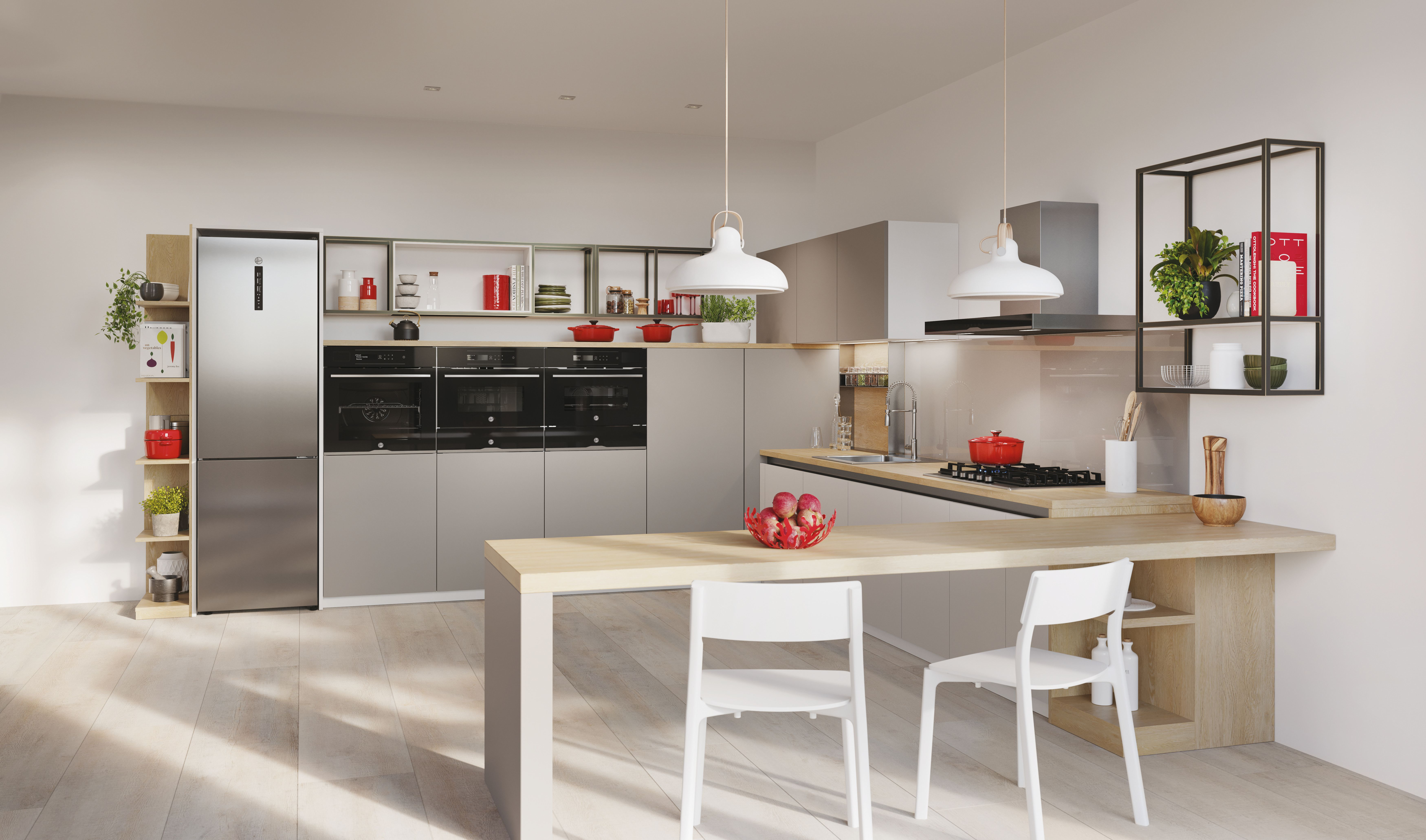 Cucina con frigorifero, forni, isola con sedie e decorazioni. Colori neutri e pavimento in legno.