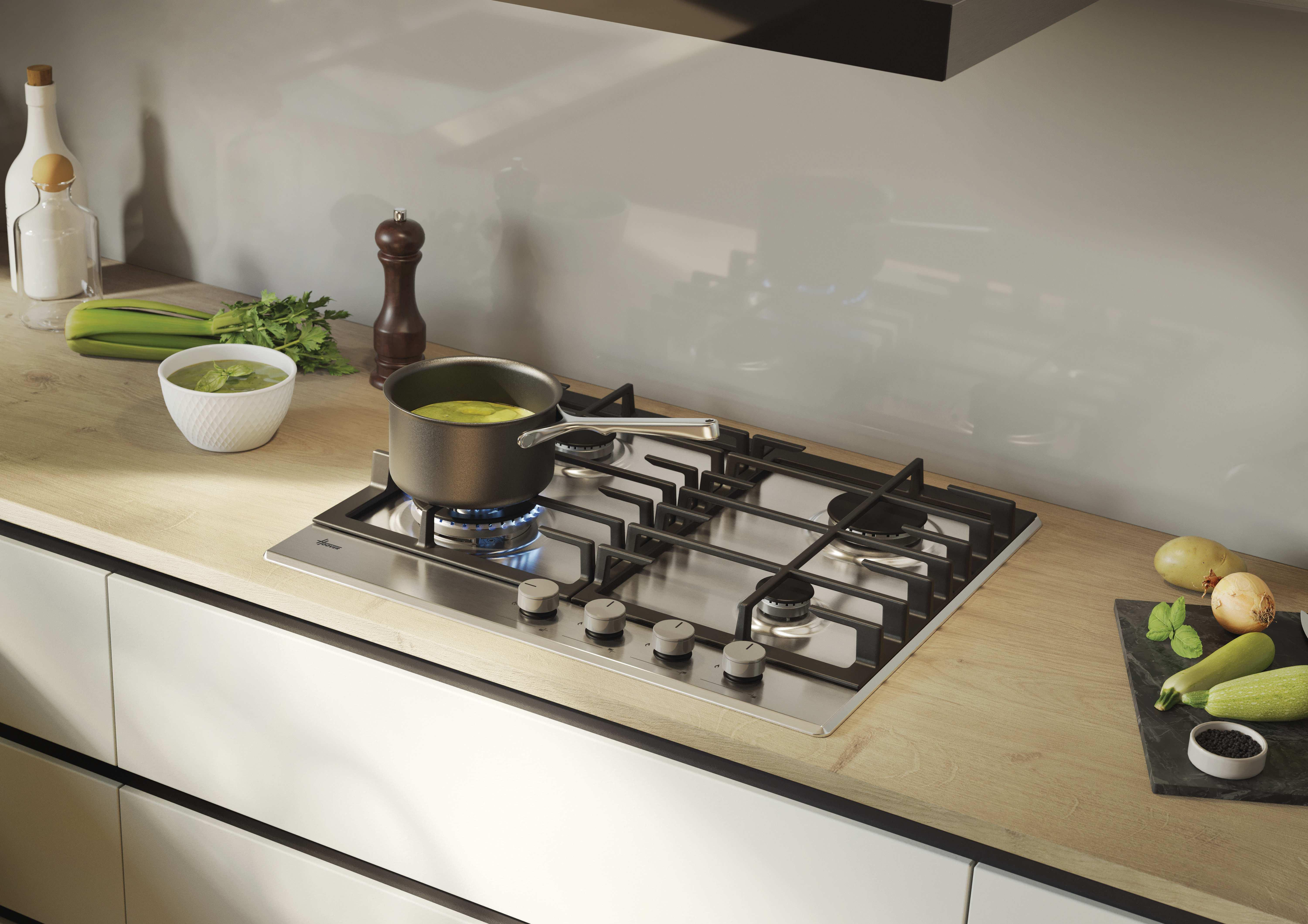 Piano cottura a gas in acciaio inox con quattro fuochi e manopole argentate. Design moderno.