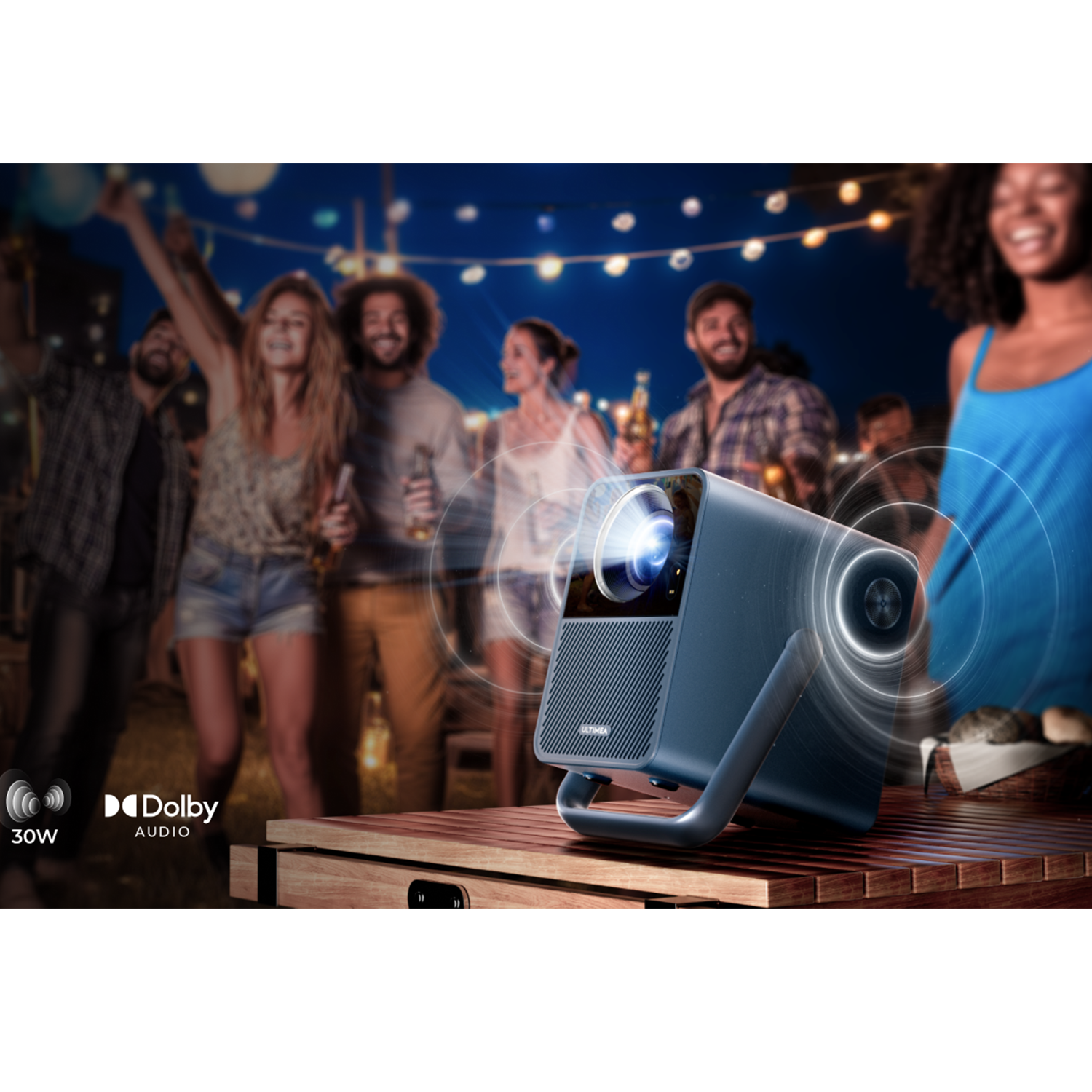 Ein blauer Projektor, der ein Bild auf einer Party projiziert. Menschen sind im Hintergrund, auf einem Holztisch.