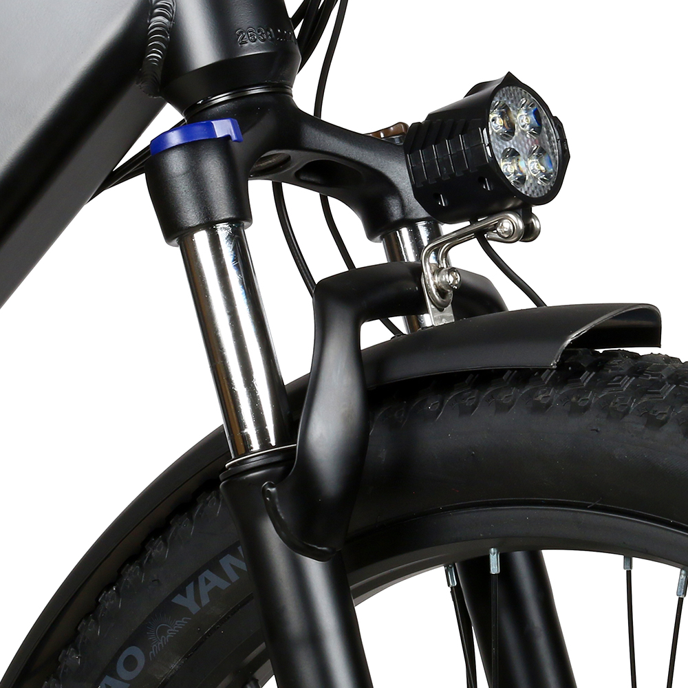 Zbliżenie przedniego widelca, reflektora i błotnika roweru. Kolory czarny i srebrny.