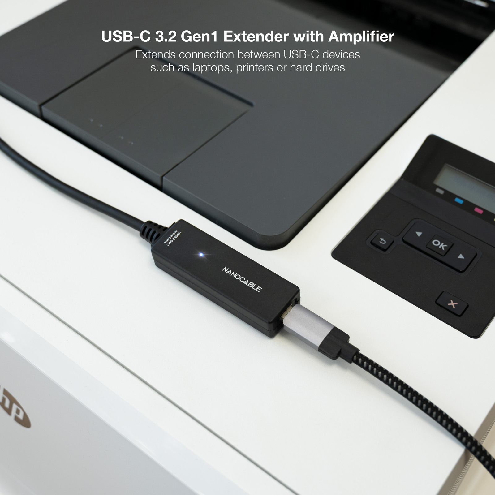 Cavo di prolunga USB-C con amplificatore collegato a una stampante e un laptop su una superficie in legno.