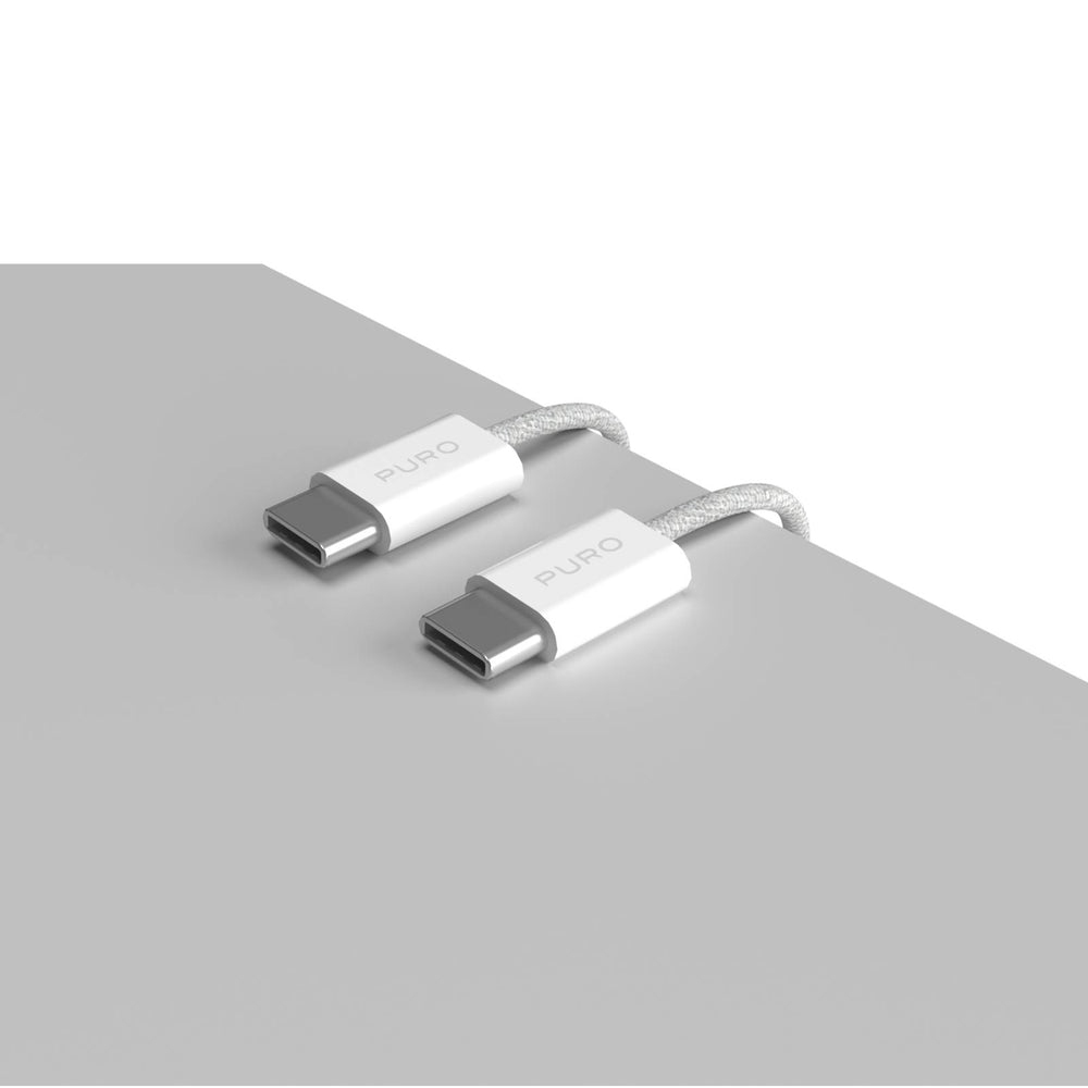 Zwei weiße USB-C-Kabel mit weißem PURO-Etikett auf grauer Oberfläche. Die Kabel sind geflochten.