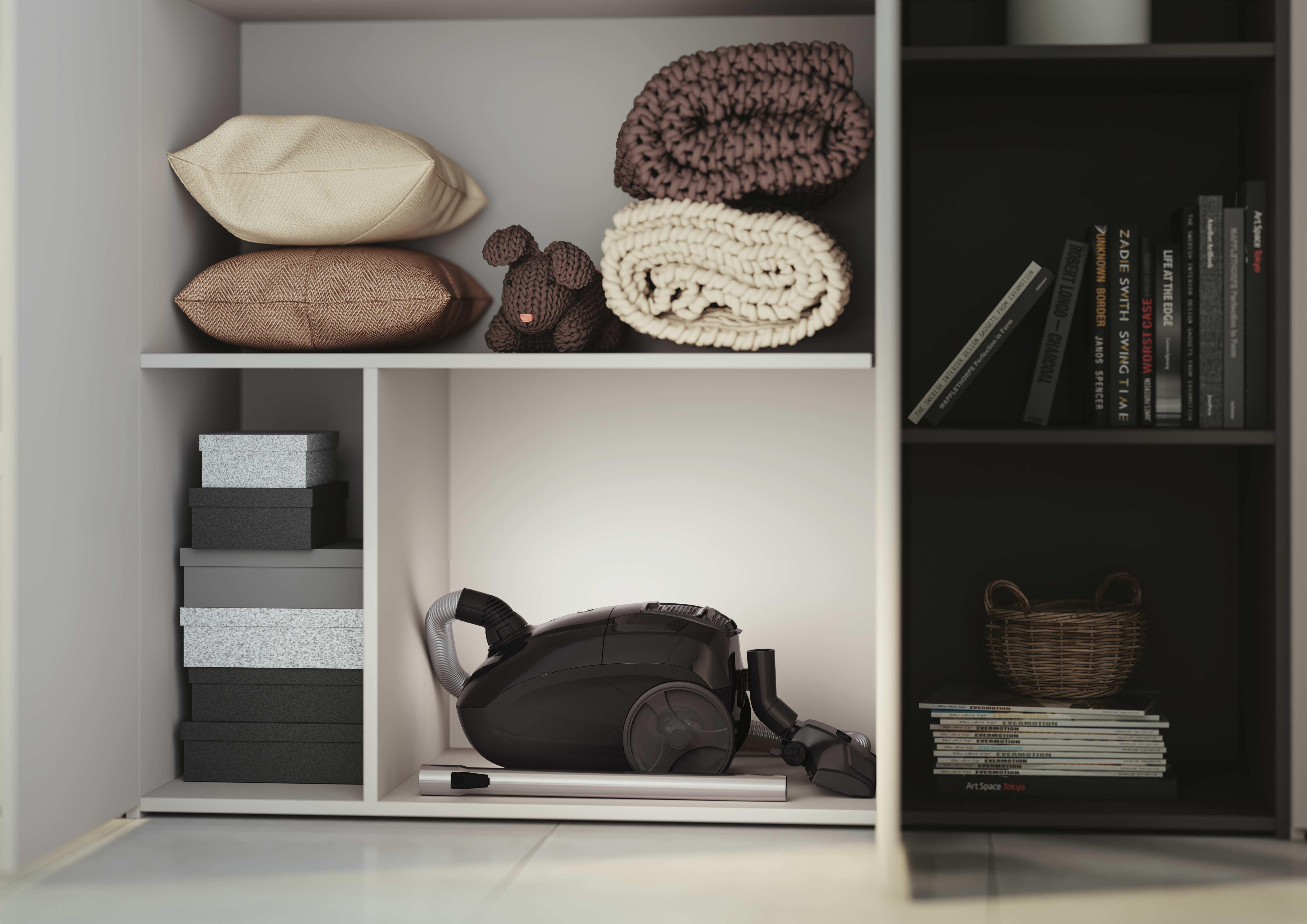Biała szafka z półkami. Widoczne poduszki, koce i odkurzacz.