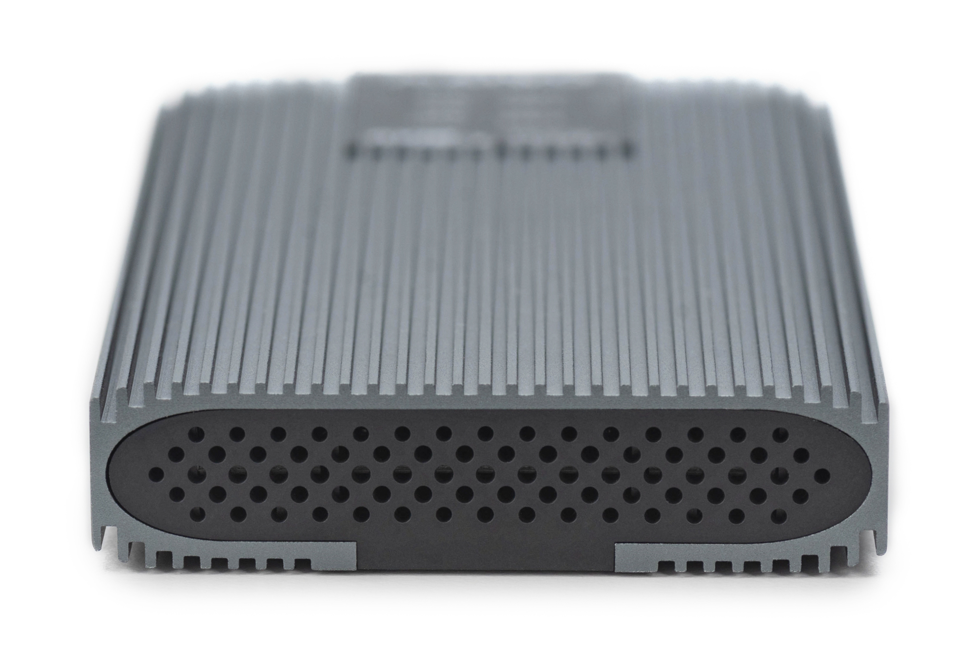 Zbliżenie szarego urządzenia do przechowywania danych. Żebrowana konstrukcja i małe otwory wentylacyjne.